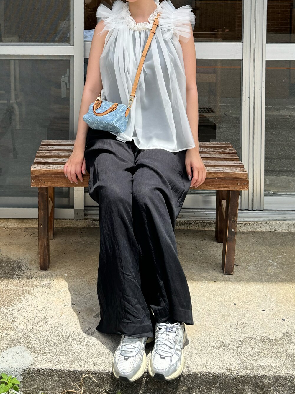 ホワイト系のベストを着用したレディースの夏コーディネートの1枚目の写真