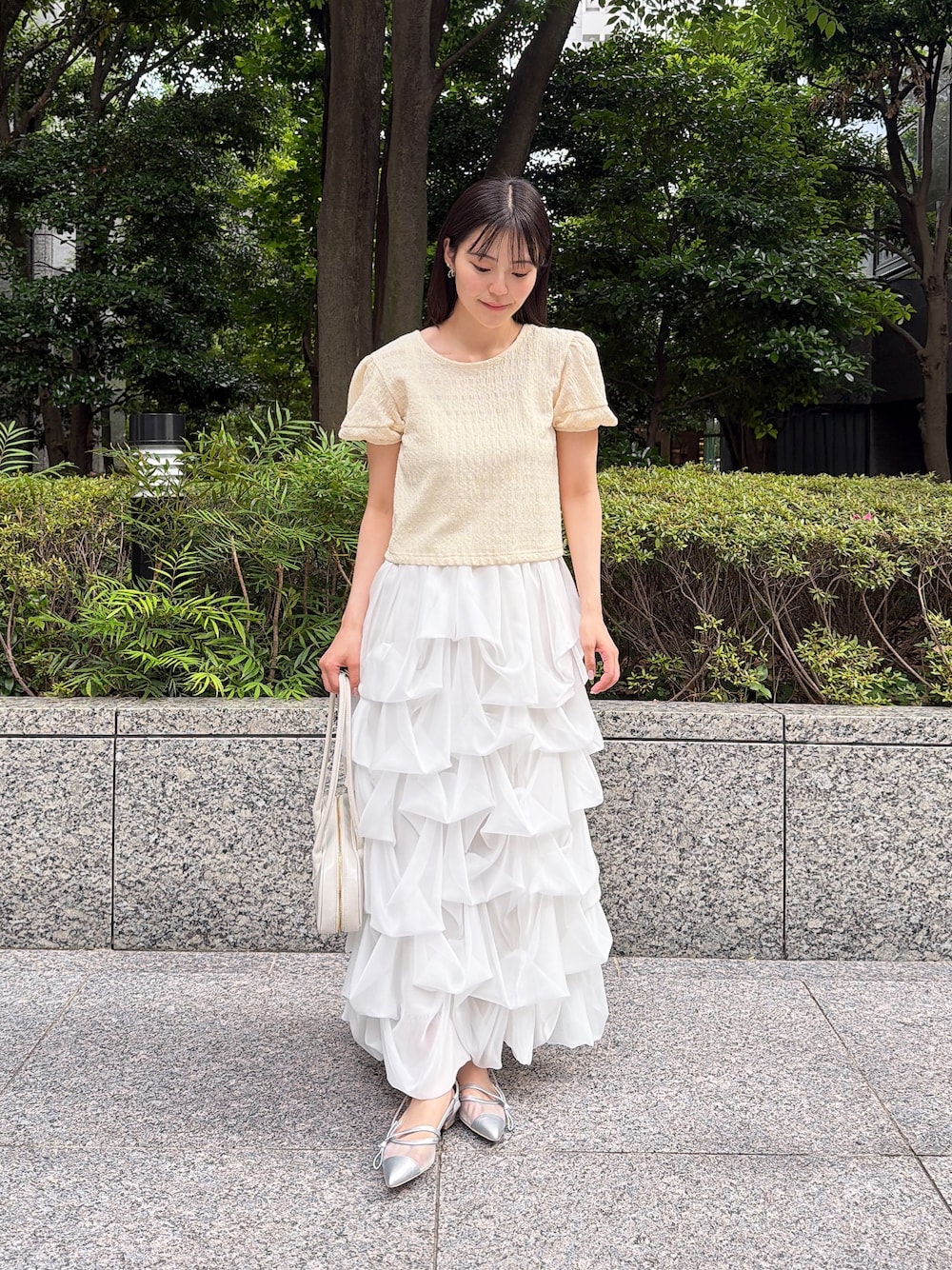 ホワイト系のスカート、イエロー系のTシャツ/カットソー、ホワイト系のショルダーバッグを着用したレディースの夏コーディネートの1枚目の写真