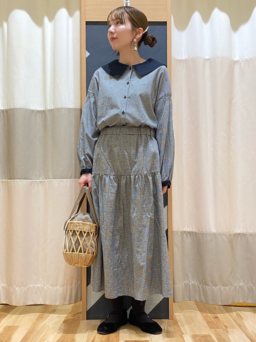 ベージュ系のハンドバッグ、グレー系のシャツ/ブラウス、グレー系のスカートを着用したレディースの冬コーディネートの1枚目の写真