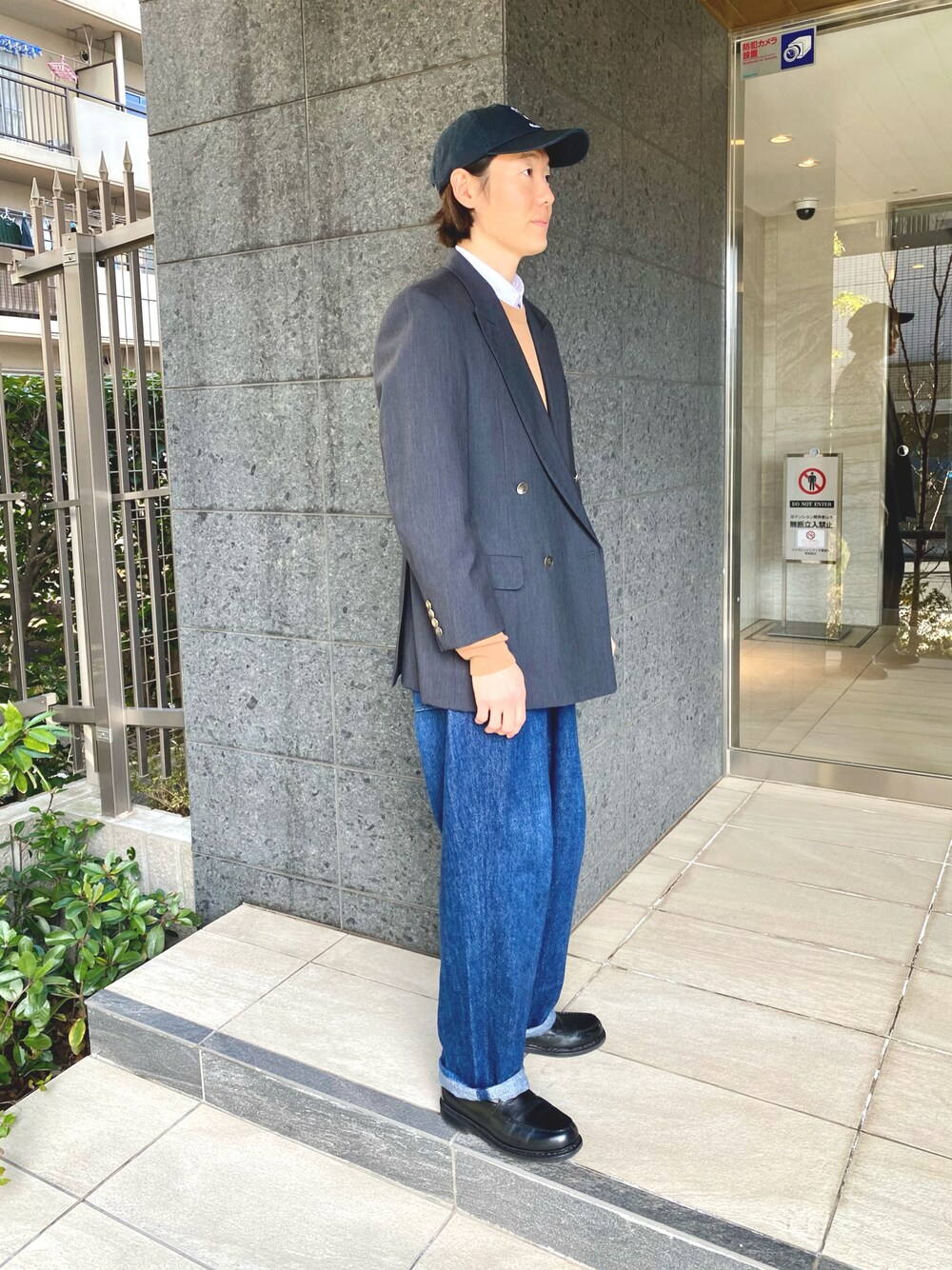 ブルー系のテーラードジャケット、ブラウン系のニット/セーター、ブルー系のデニムパンツを着用したメンズの冬コーディネートの1枚目の写真