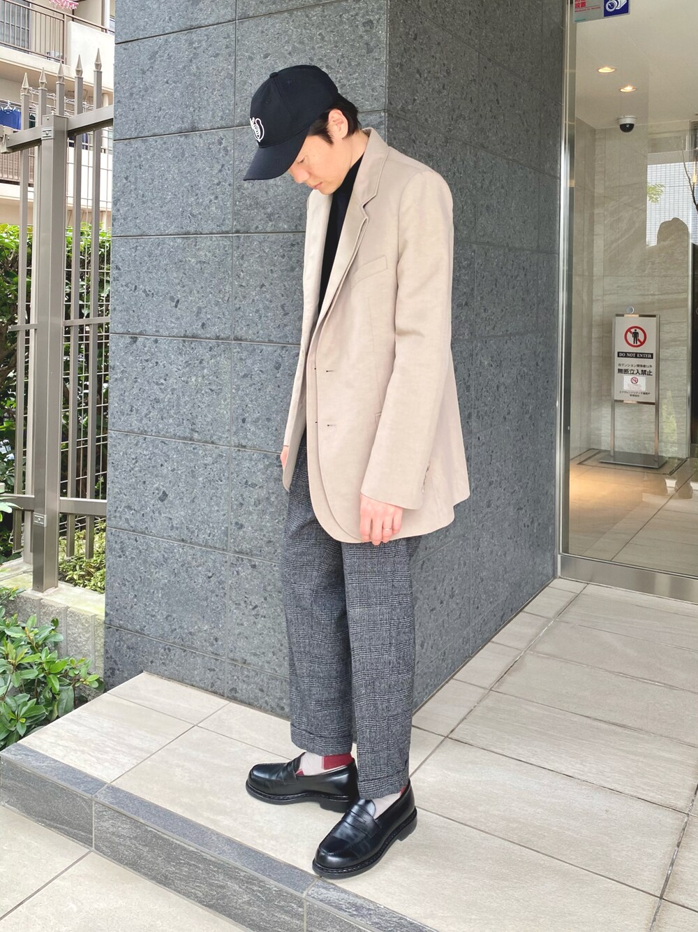 ベージュ系のテーラードジャケット、グレー系のパンツ、ブラック系のローファーを着用したメンズの秋コーディネートの1枚目の写真