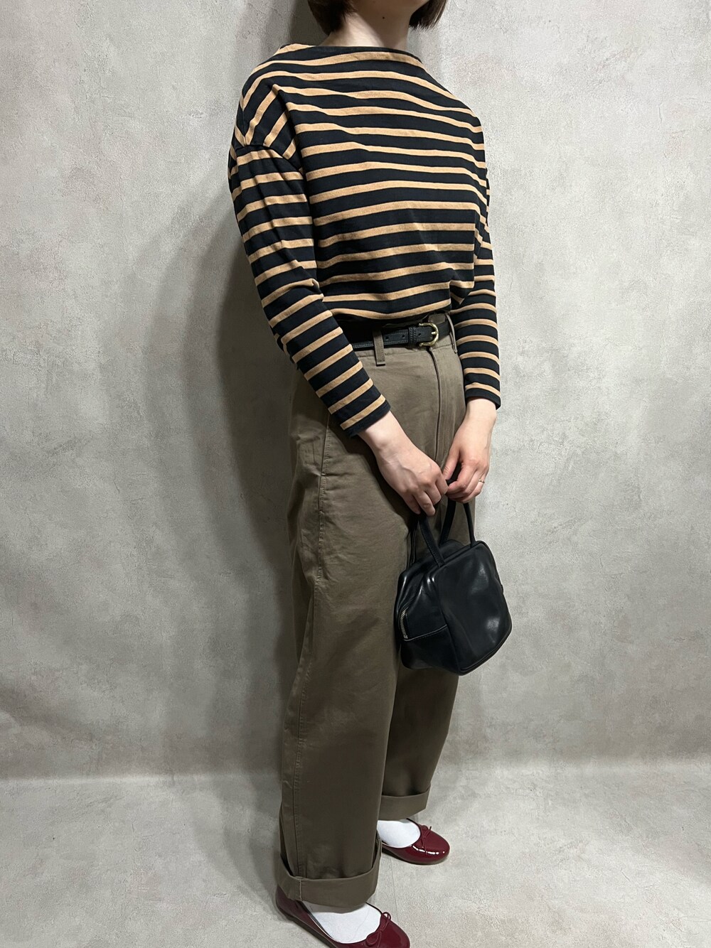 ブラック系のTシャツ/カットソー、ベージュ系のパンツを着用したレディースの春コーディネートの1枚目の写真