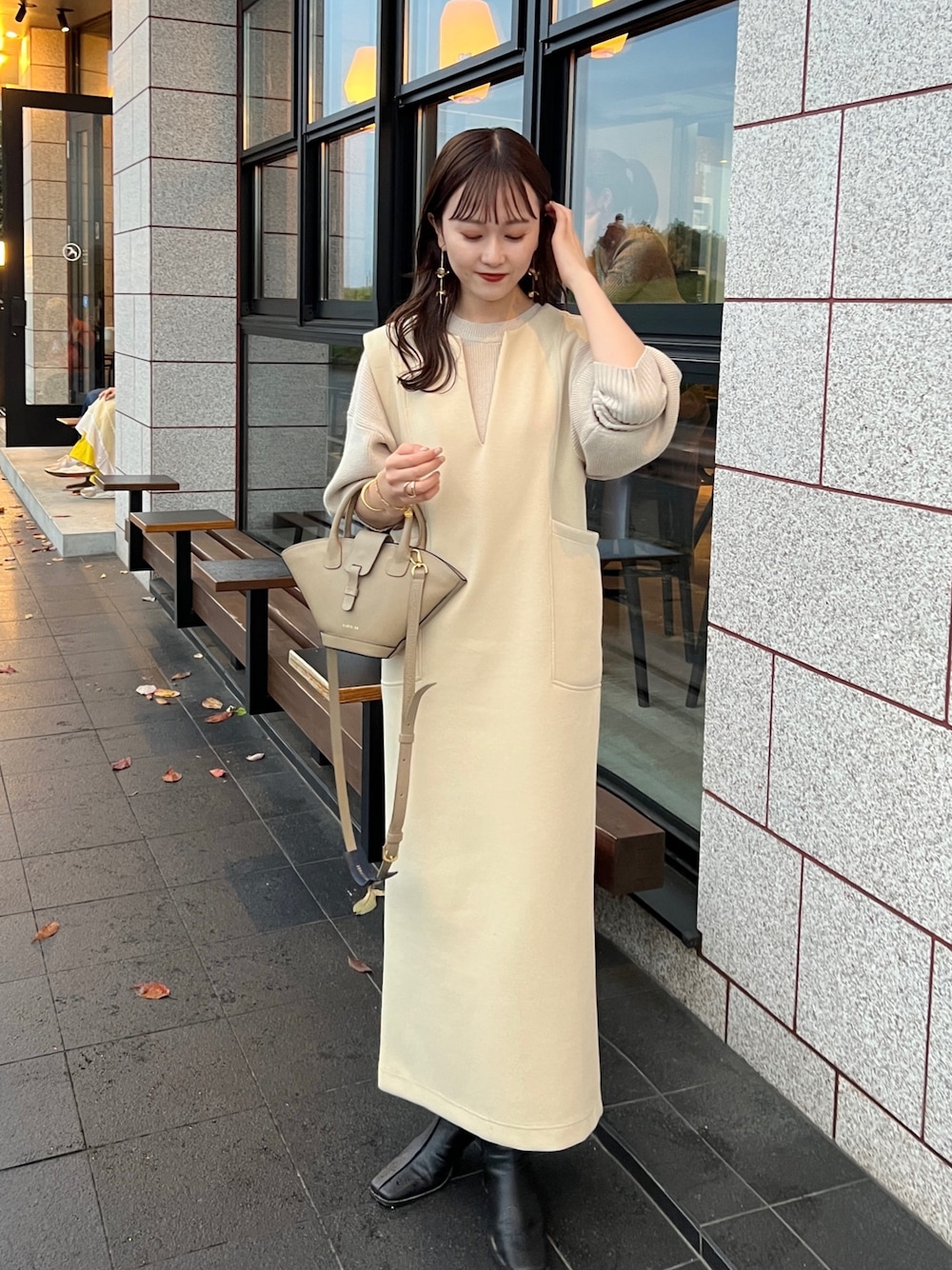 ベージュ系のワンピース、ベージュ系のニット/セーター、ブラック系のブーツを着用したレディースの秋コーディネートの1枚目の写真