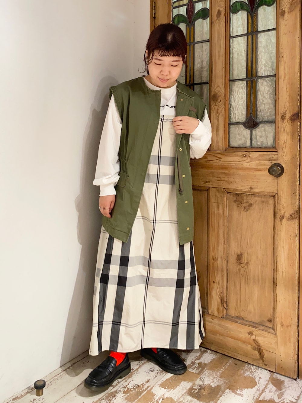 グリーン系のミリタリージャケット、ベージュ系のワンピース、ブラック系のローファーを着用したレディースの秋コーディネートの1枚目の写真