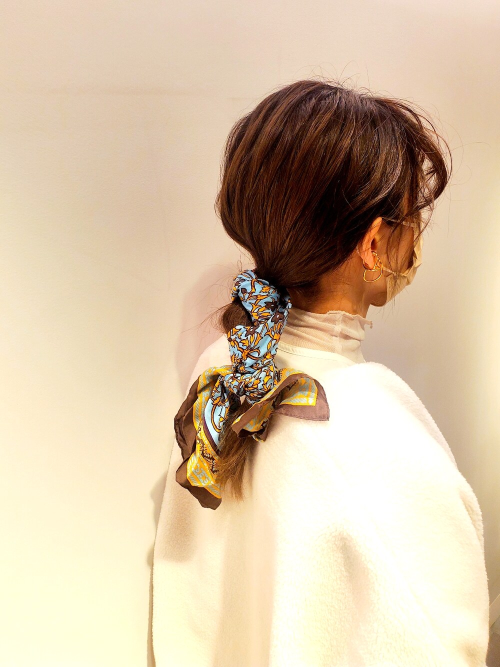 ホワイト系のシャツ/ブラウス、ゴールド系のパンプス、ベージュ系のトップスを着用したレディースの冬コーディネートの2枚目の写真