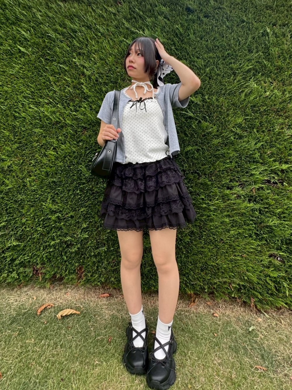 ブラック系のサンダル、ブラック系のスカート、ホワイト系のキャミソールを着用したレディースの夏コーディネートの1枚目の写真