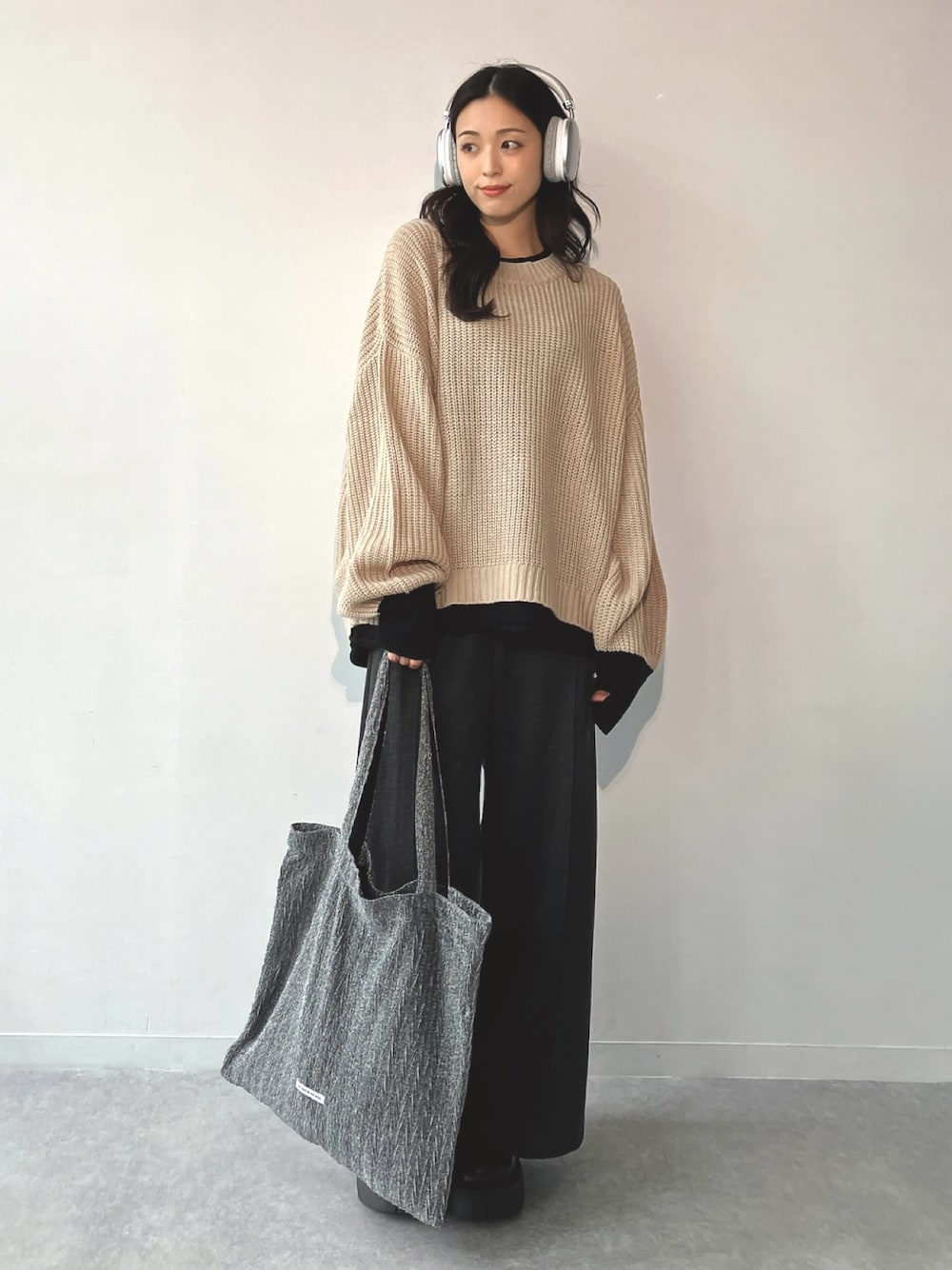 ブラック系のサンダル、ベージュ系のニット/セーター、グレー系のスラックスを着用したレディースの冬コーディネートの1枚目の写真