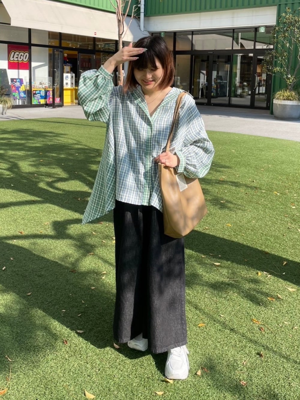 ブルー系のチュニック、ブラック系のその他パンツ、ベージュ系のトートバッグを着用したレディースの春コーディネートの1枚目の写真