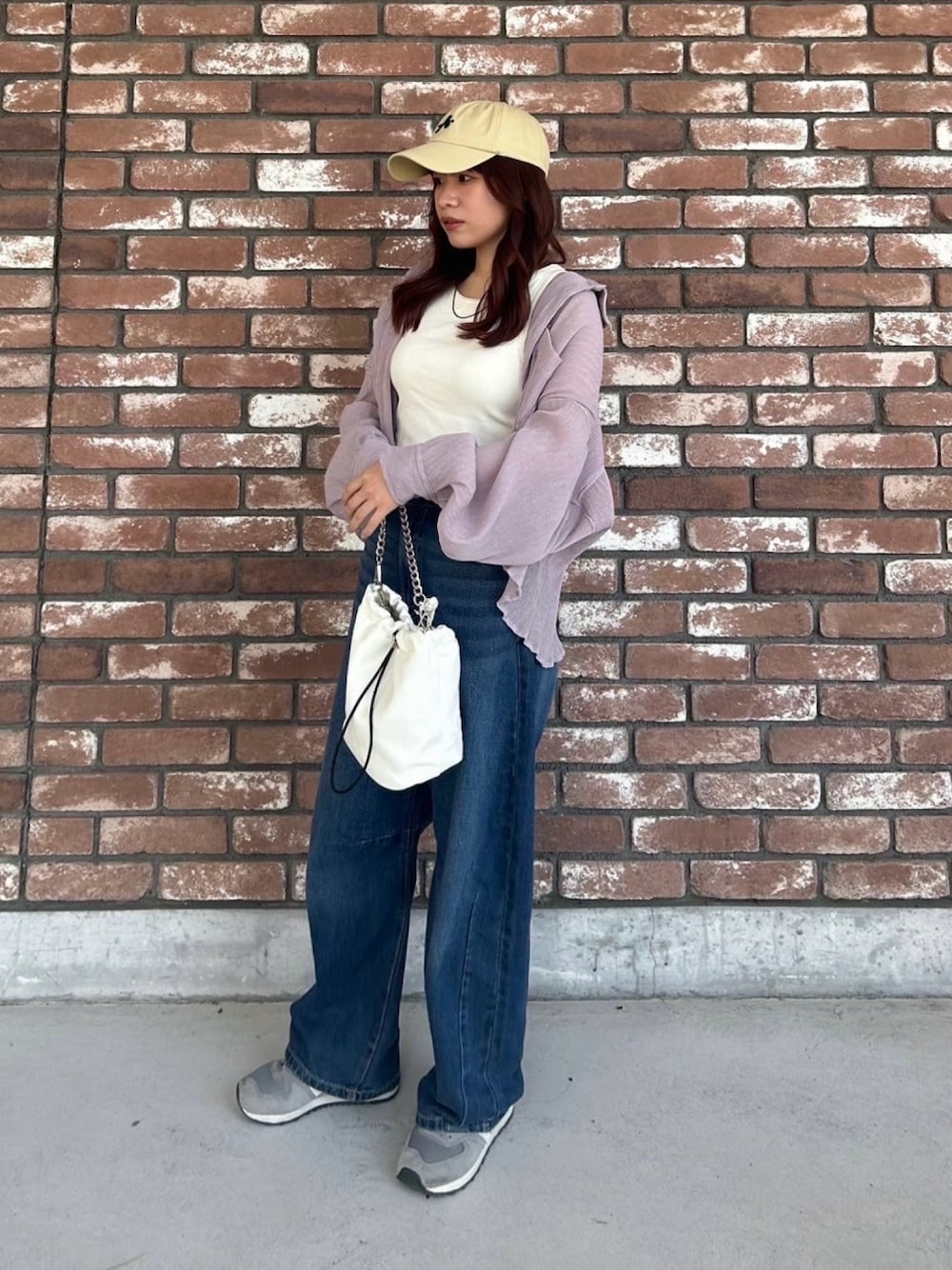 ブルー系のデニムパンツ、ホワイト系のショルダーバッグ、ピンク系のシャツ/ブラウスを着用したレディースの春コーディネートの1枚目の写真