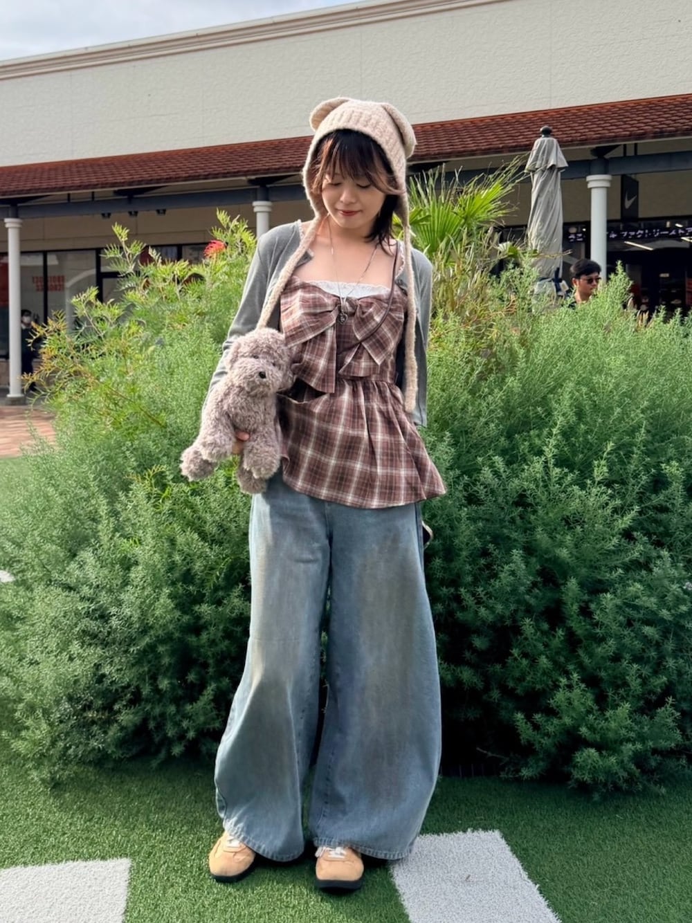 ブルー系のデニムパンツ、ブラウン系のチュニック、グレー系のショルダーバッグを着用したレディースの秋コーディネートの1枚目の写真
