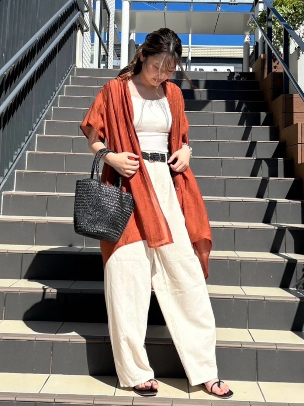 オレンジ系のワンピース、ホワイト系のキャミソール、ホワイト系のその他パンツを着用したレディースの夏コーディネートの1枚目の写真