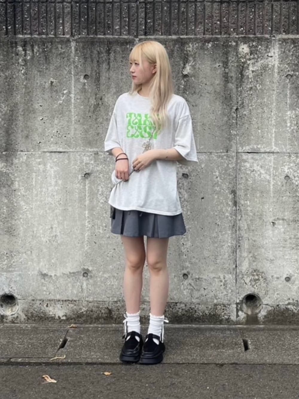 ベージュ系のTシャツ/カットソー、グレー系のスカート、シルバー系のスマホグッズを着用したレディースの夏コーディネートの1枚目の写真