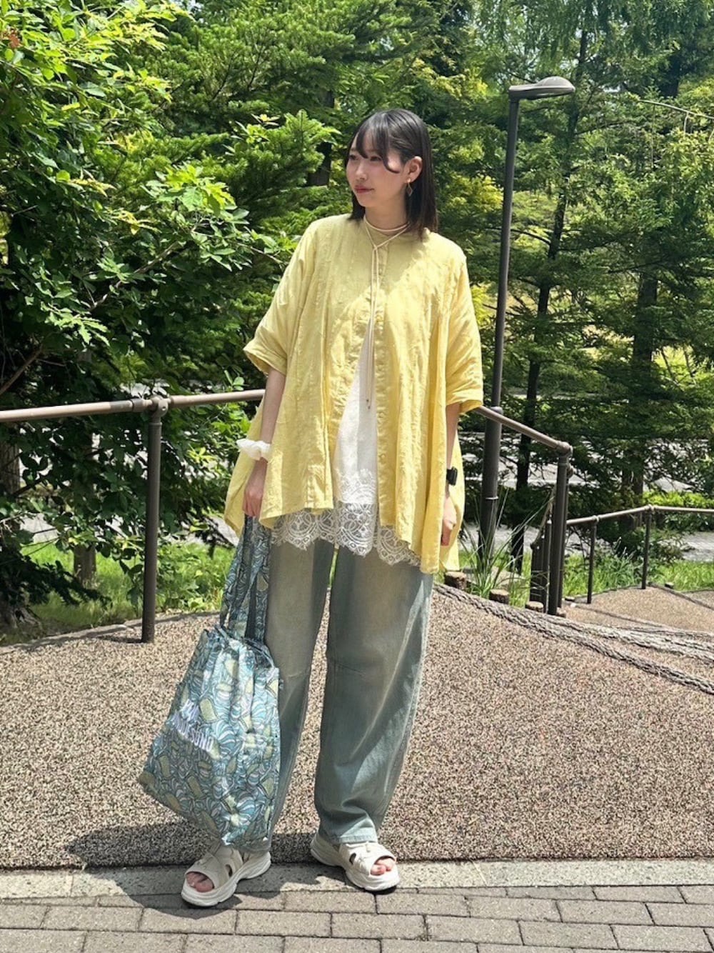 ブルー系のデニムパンツ、イエロー系のシャツ/ブラウス、ホワイト系のキャミソールを着用したレディースの夏コーディネートの1枚目の写真