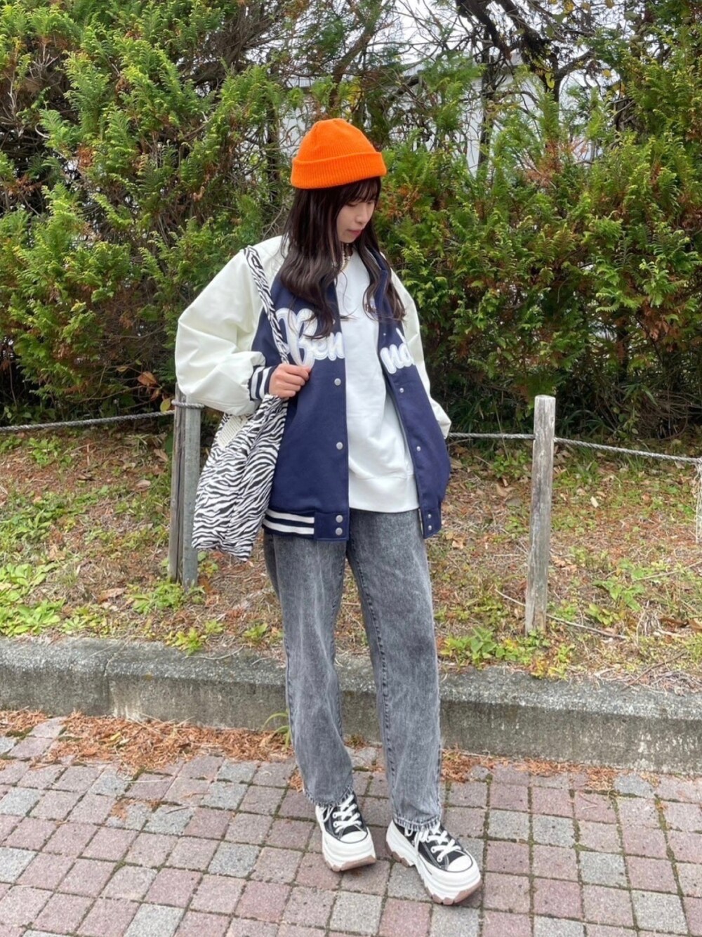 その他のトートバッグ、ブラック系のデニムパンツ、ブルー系のスタジャンを着用したレディースの冬コーディネートの1枚目の写真
