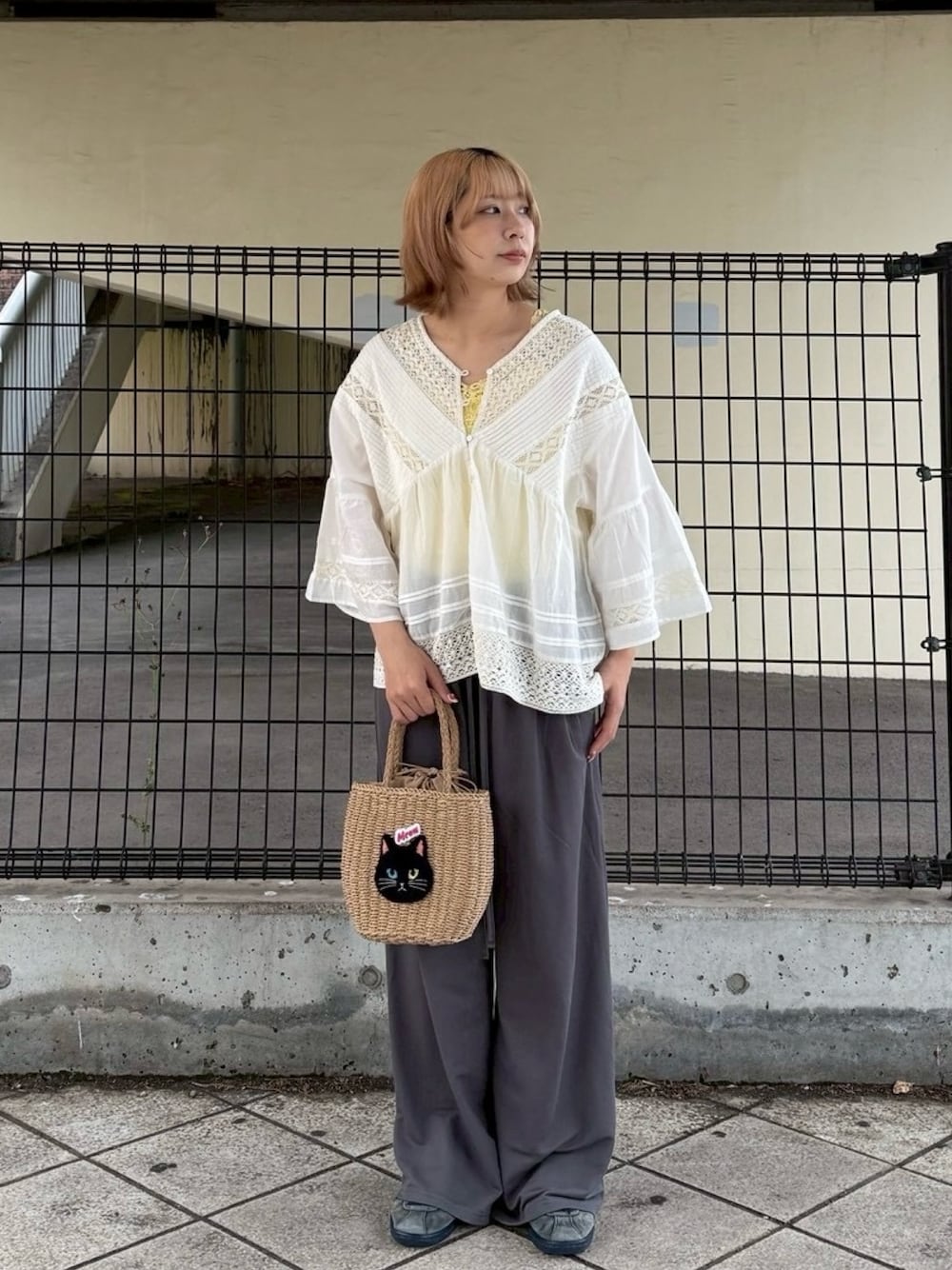 ホワイト系のシャツ/ブラウス、イエロー系のタンクトップ、グレー系のスラックスを着用したレディースの夏コーディネートの1枚目の写真
