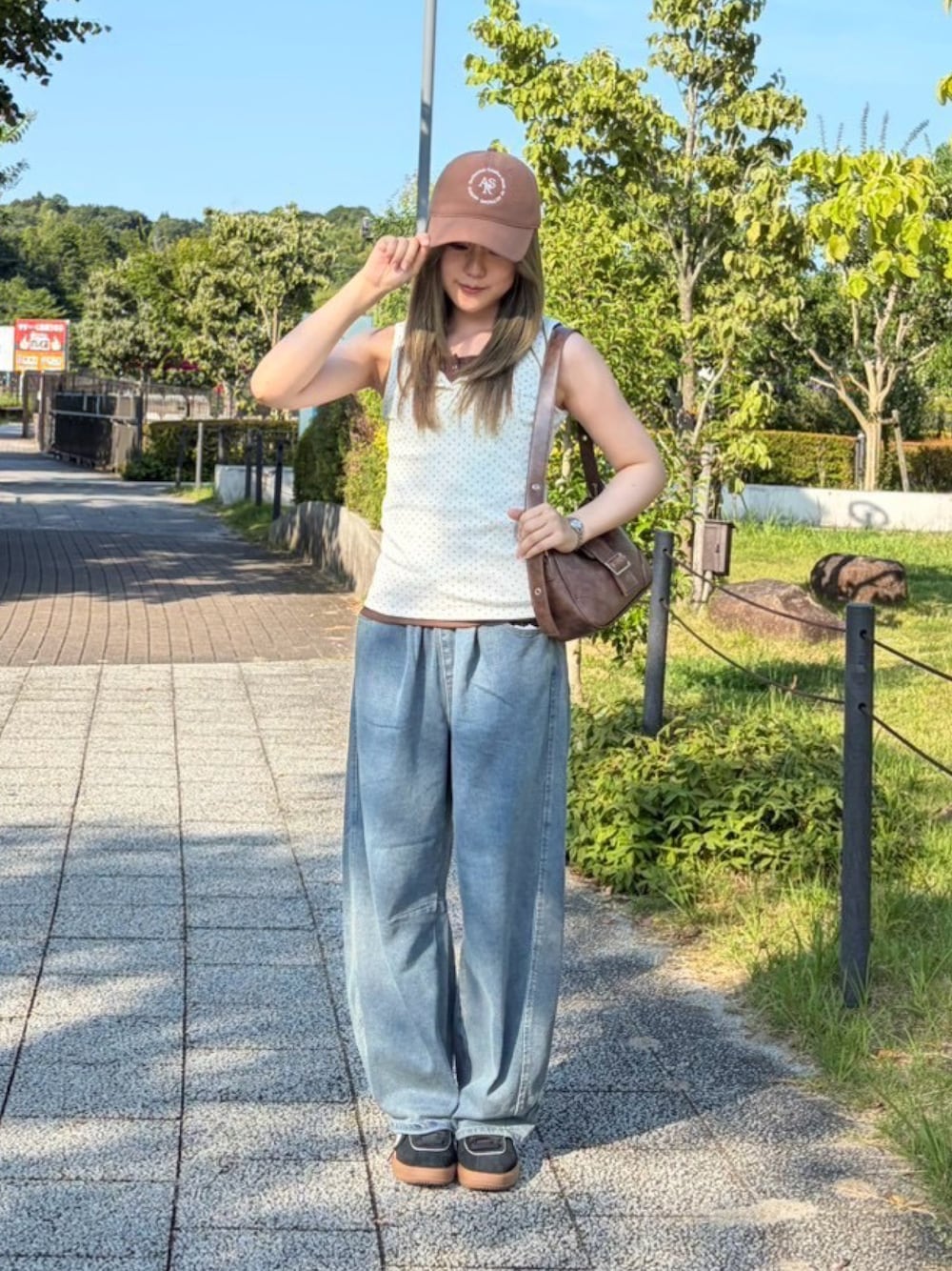 ブラウン系のタンクトップ、ブルー系のデニムパンツ、ベージュ系のタンクトップを着用したレディースの夏コーディネートの1枚目の写真