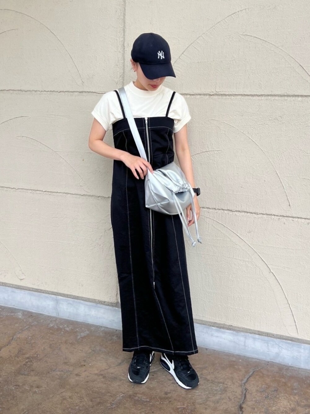 ブラック系のワンピース、ホワイト系のTシャツ/カットソー、シルバー系のショルダーバッグを着用したレディースの夏コーディネートの1枚目の写真