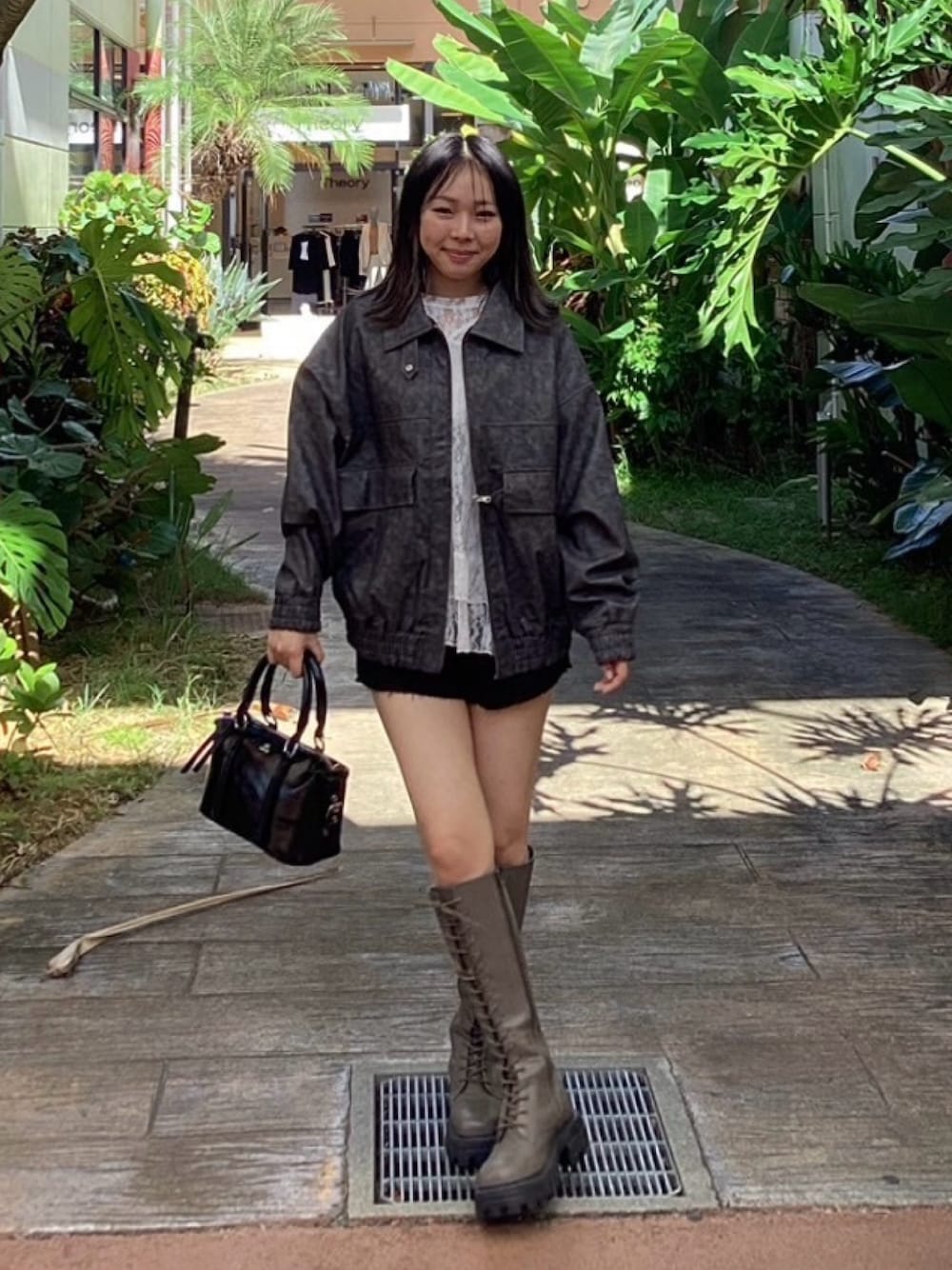 グレー系のブルゾン、ホワイト系のTシャツ/カットソー、ブラック系のデニムパンツを着用したレディースの秋コーディネートの1枚目の写真