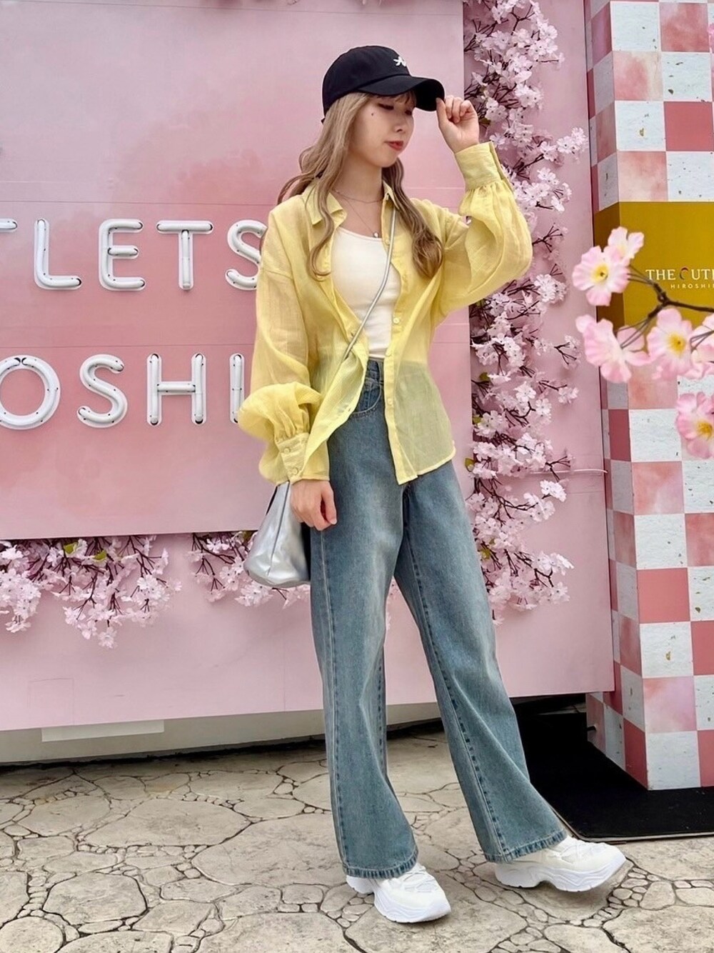 ブルー系のデニムパンツ、シルバー系のショルダーバッグ、イエロー系のシャツ/ブラウスを着用したレディースの春コーディネートの1枚目の写真