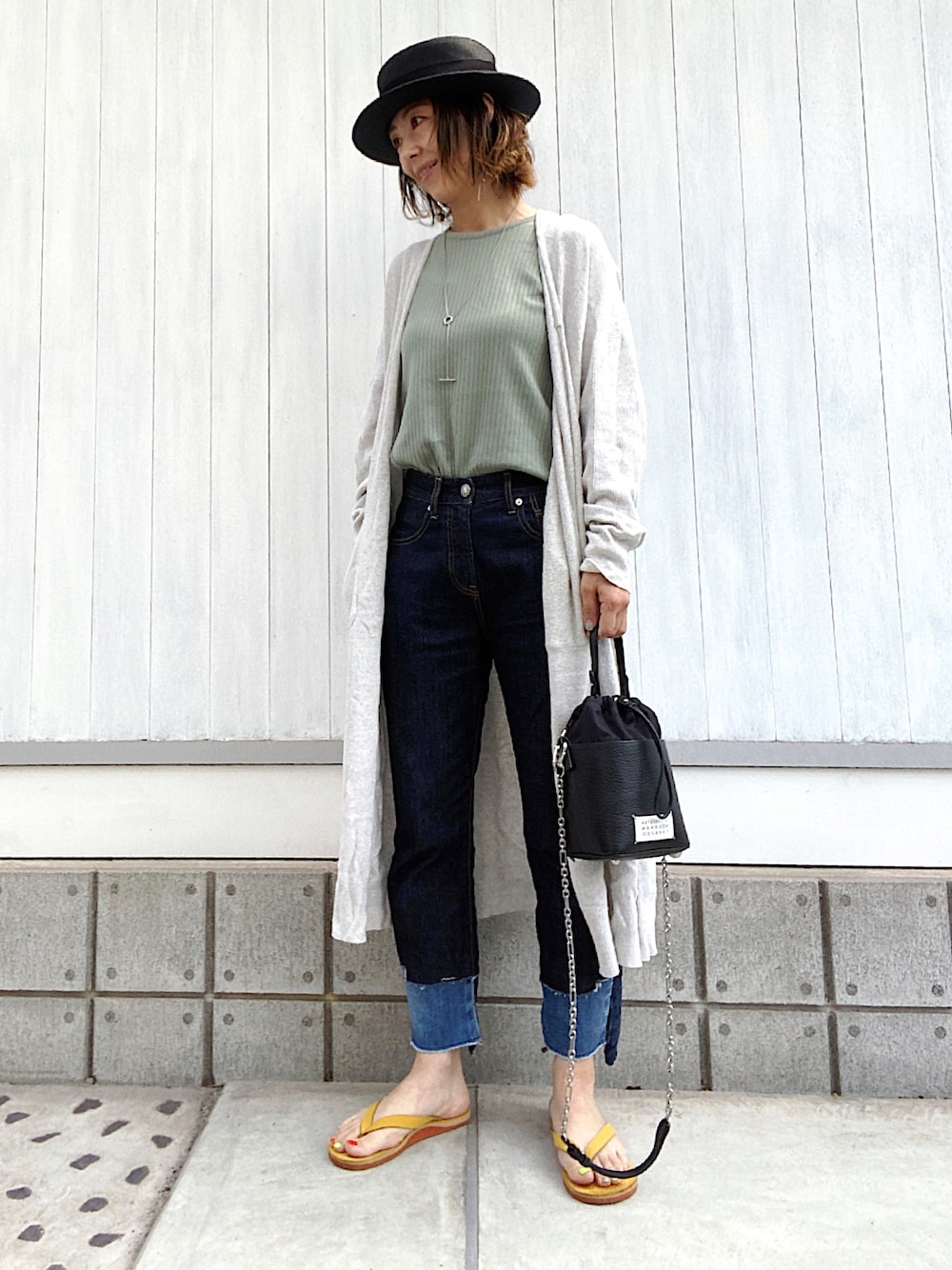 グリーン系のTシャツ/カットソー、ブルー系のデニムパンツ、イエロー系のサンダルを着用したレディースの春コーディネートの1枚目の写真