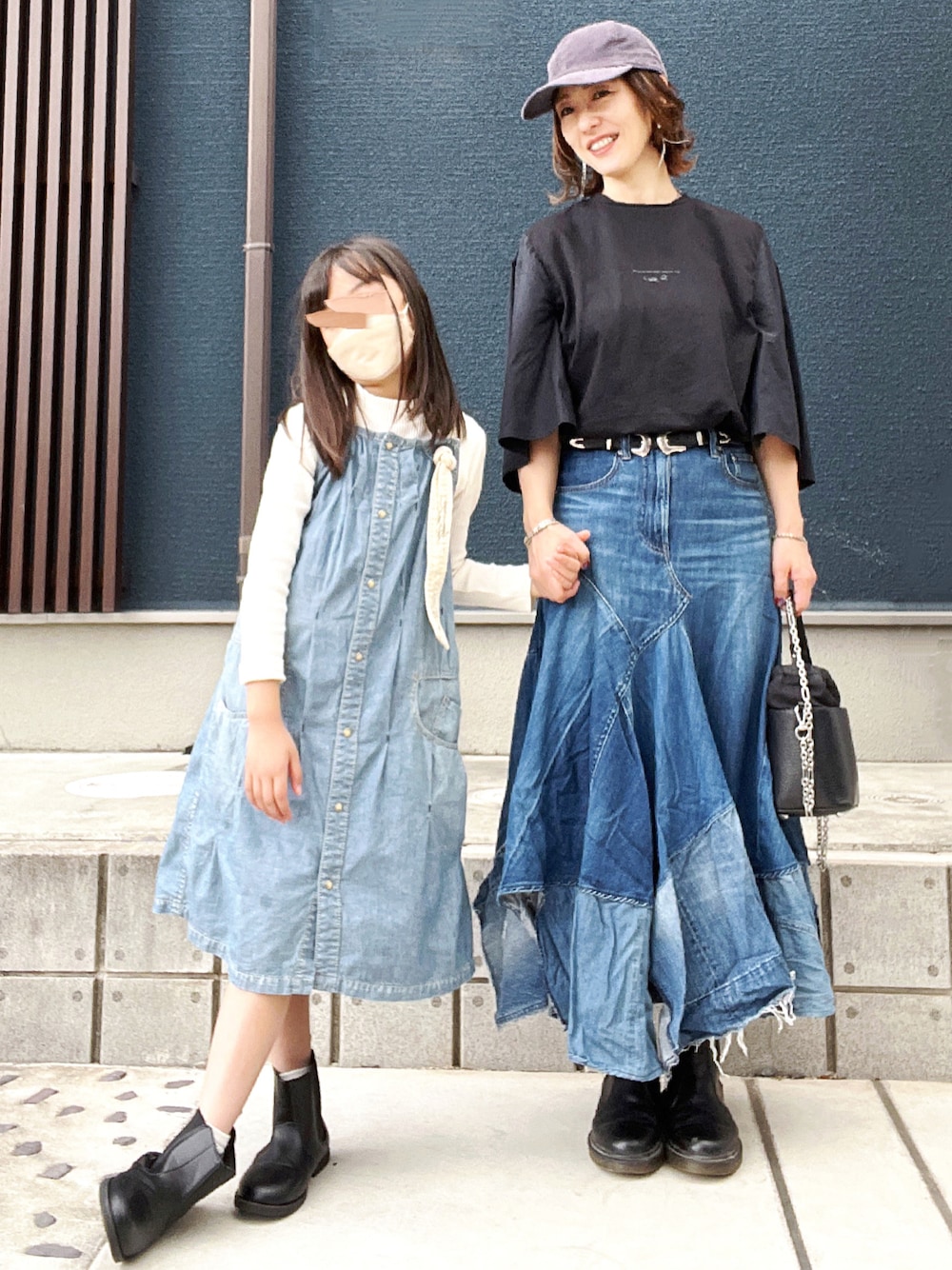 ブラック系のTシャツ/カットソー、ブルー系のデニムスカート、ブラック系のブーツを着用したレディースの秋コーディネートの1枚目の写真