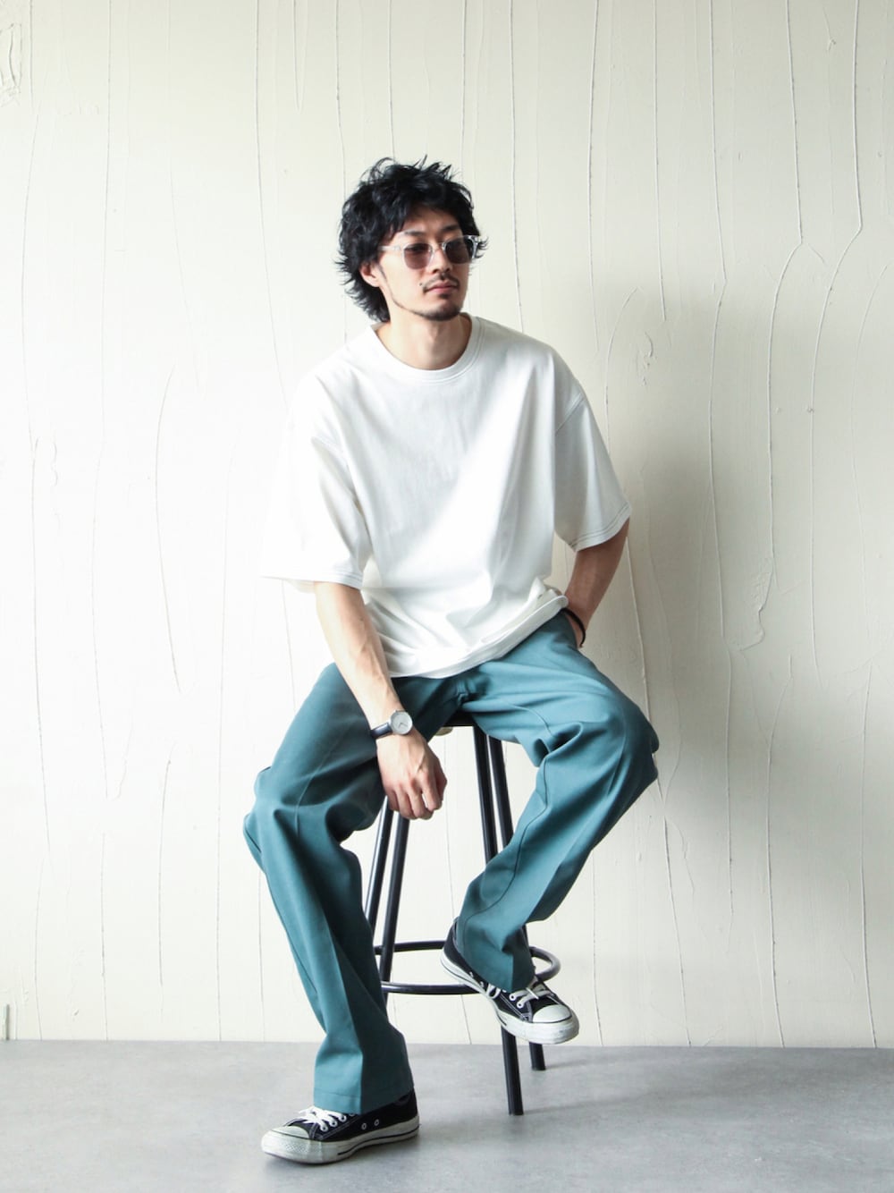 グリーン系のチノパンツ、ホワイト系のTシャツ/カットソー、ブラック系のスニーカーを着用したメンズの夏コーディネートの1枚目の写真