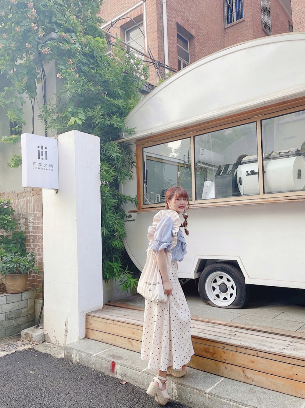 ブルー系のシャツ/ブラウス、ホワイト系のスカート、ホワイト系のトートバッグを着用したレディースの秋コーディネートの1枚目の写真