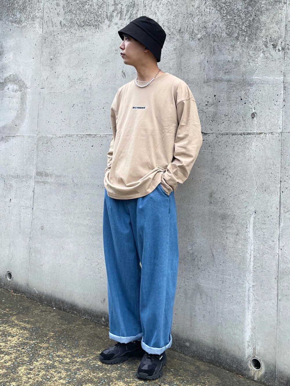 ベージュ系のトップス、ブラック系のスニーカー、ブルー系のデニムパンツを着用したメンズの夏コーディネートの1枚目の写真