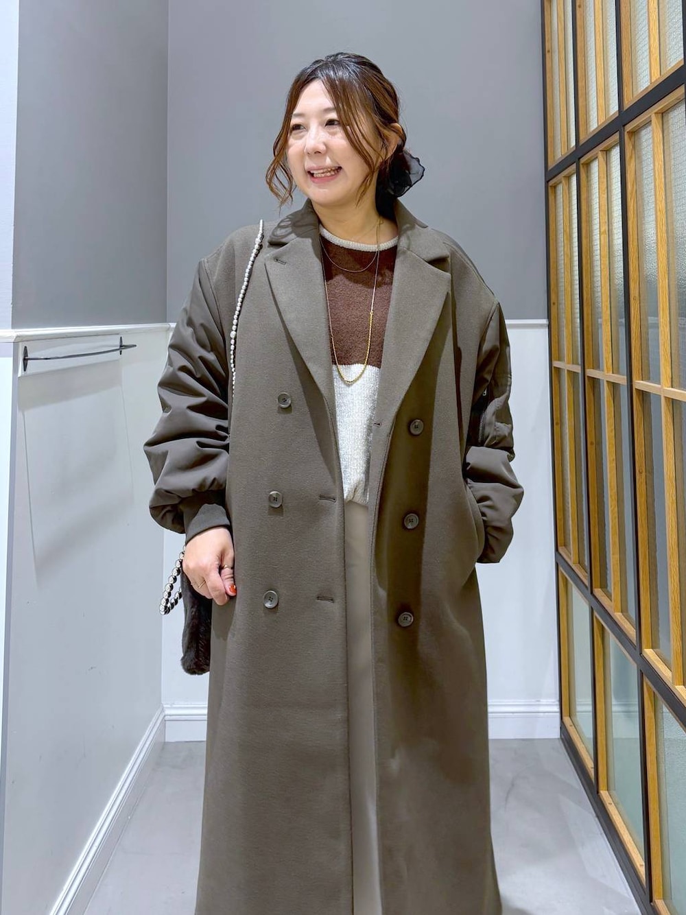 ホワイト系のスカート、ブラック系のブーツ、グレー系のショルダーバッグを着用したレディースの秋コーディネートの1枚目の写真