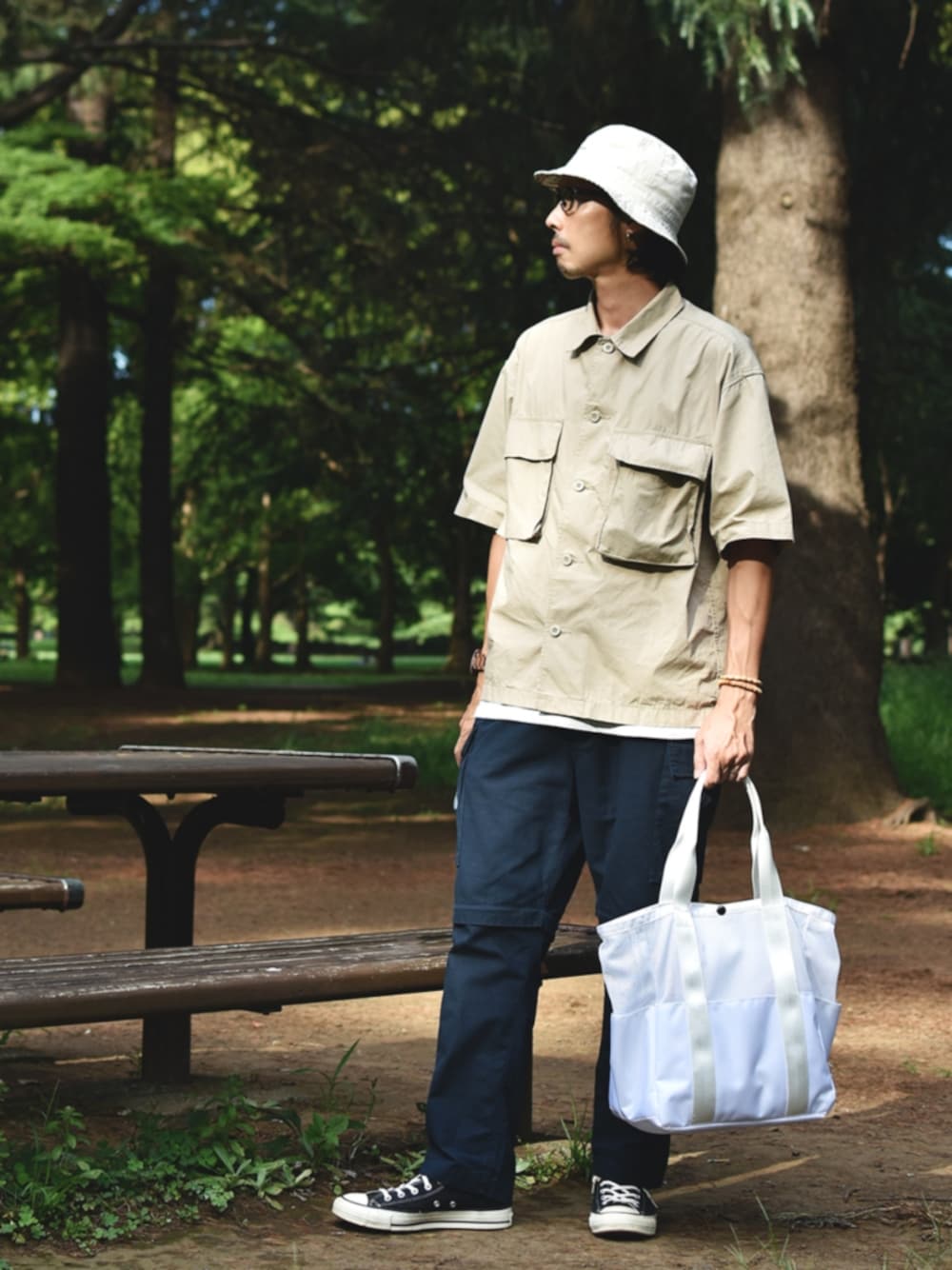 ブルー系のカーゴパンツ、ベージュ系のシャツ/ブラウス、ホワイト系のハンドバッグを着用したメンズの夏コーディネートの1枚目の写真