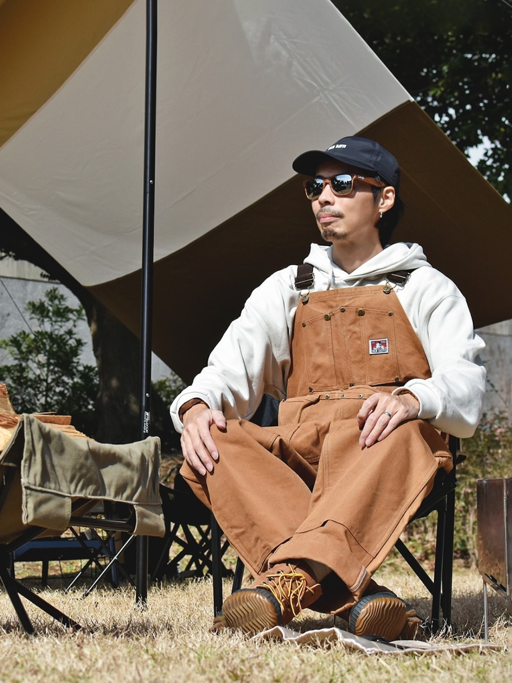 「キャンプスタイル、アウトドアスタイル、春服デビュー宣言、オーバーオール、パーカー、キャップ、サングラス、ビッグシルエット、ブーツ」｜「BEN DAVISのアイテム（サロペット/オーバーオール、ブラウン系）」を使った、つちぽんさん（メンズ・177cm）の春コーディネートの1枚目の写真