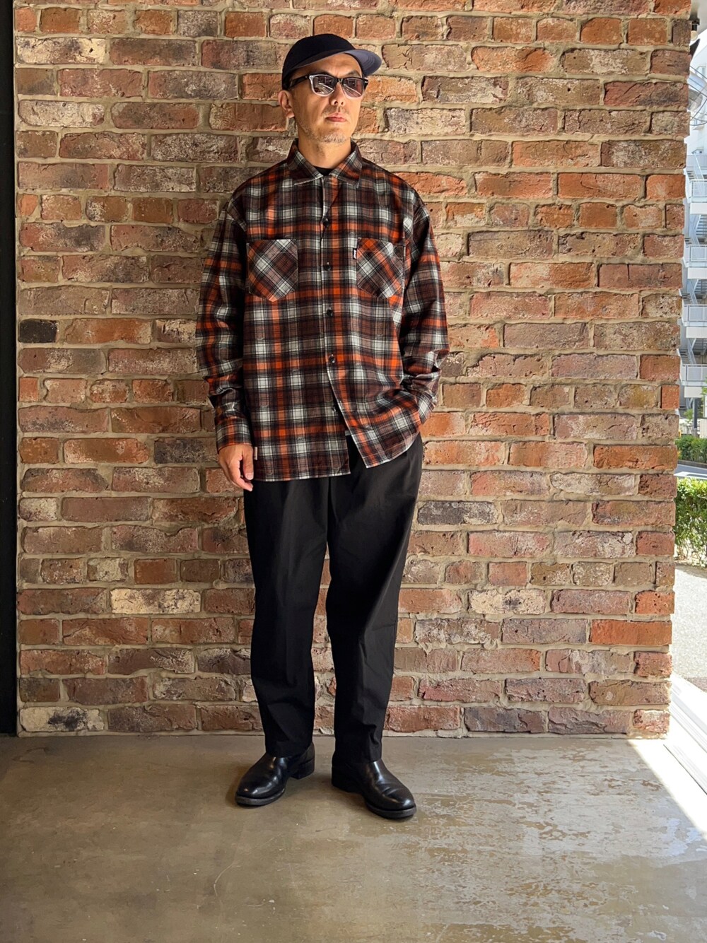 ブラック系のチノパンツ、オレンジ系のシャツ/ブラウスを着用したメンズの夏コーディネートの1枚目の写真