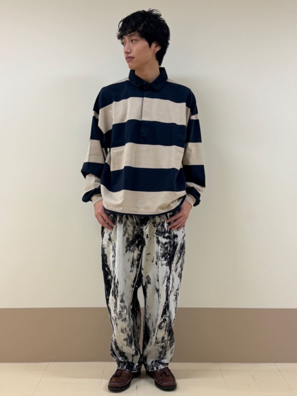 ブラック系のデニムパンツ、ベージュ系のポロシャツを着用したメンズの冬コーディネートの1枚目の写真