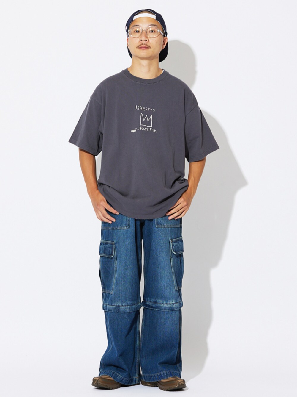 ブルー系のデニムパンツ、ブラック系のTシャツ/カットソー、ブラウン系のスニーカーを着用したメンズの夏コーディネートの1枚目の写真