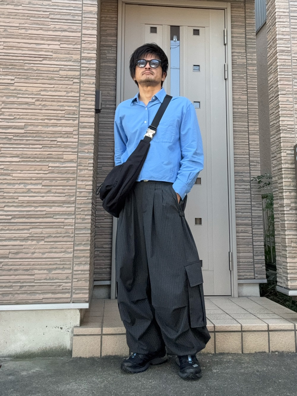 その他のカーゴパンツ、ブラック系のショルダーバッグ、ブラック系のスニーカーを着用したメンズの秋コーディネートの1枚目の写真