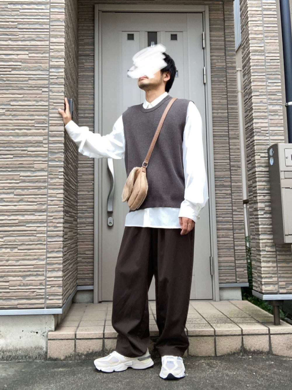 ブラウン系のスラックス、ベージュ系のスニーカー、イエロー系のショルダーバッグを着用したメンズの秋コーディネートの1枚目の写真