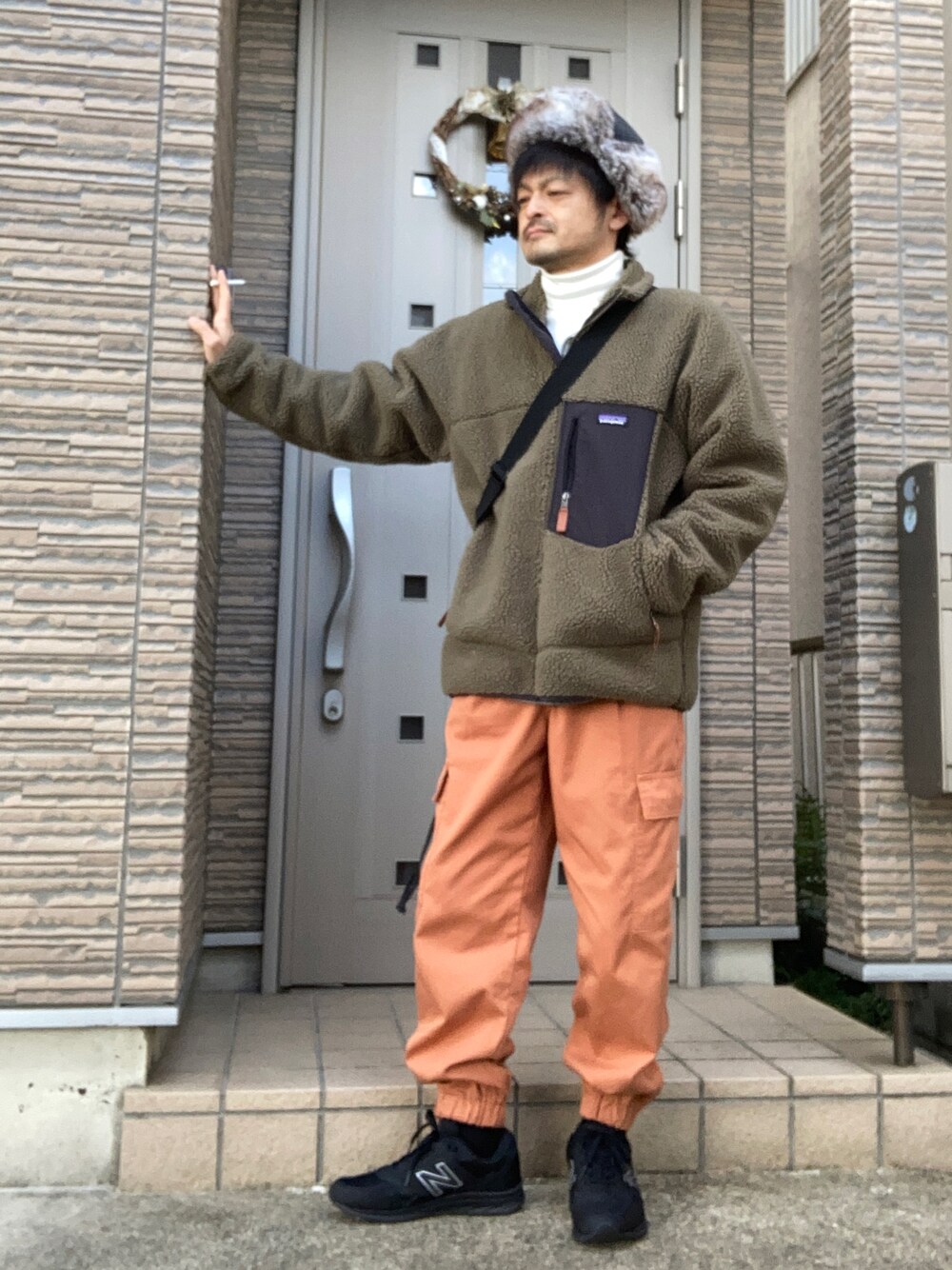 「冬コーデ、フライトキャップ、カーゴパンツ、patagonia、GU、スニーカー、ニューバランス、New Balance、雨の日コーデ、GORE-TEX、タートルネック、カジュアル」｜「GUのアイテム（カーゴパンツ、オレンジ系）」を使った、タルナンドさん（メンズ・165cm）の冬コーディネートの1枚目の写真