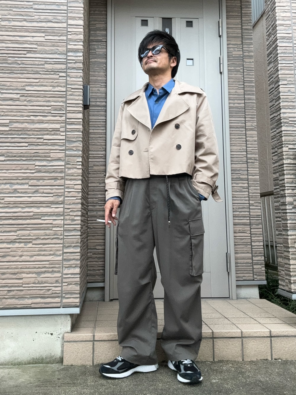 「秋コーデ、トレンチコート、カーゴパンツ、きれいめカジュアル、サングラス、スニーカー、ニューバランス、New Balance、青シャツ、シャツスタイル」｜「WYM LIDNMのDRAPE LOOSE WASHER CARGO（カーゴパンツ、グレー系）」を使った、タルナンドさん（メンズ・165cm）の冬コーディネートの1枚目の写真