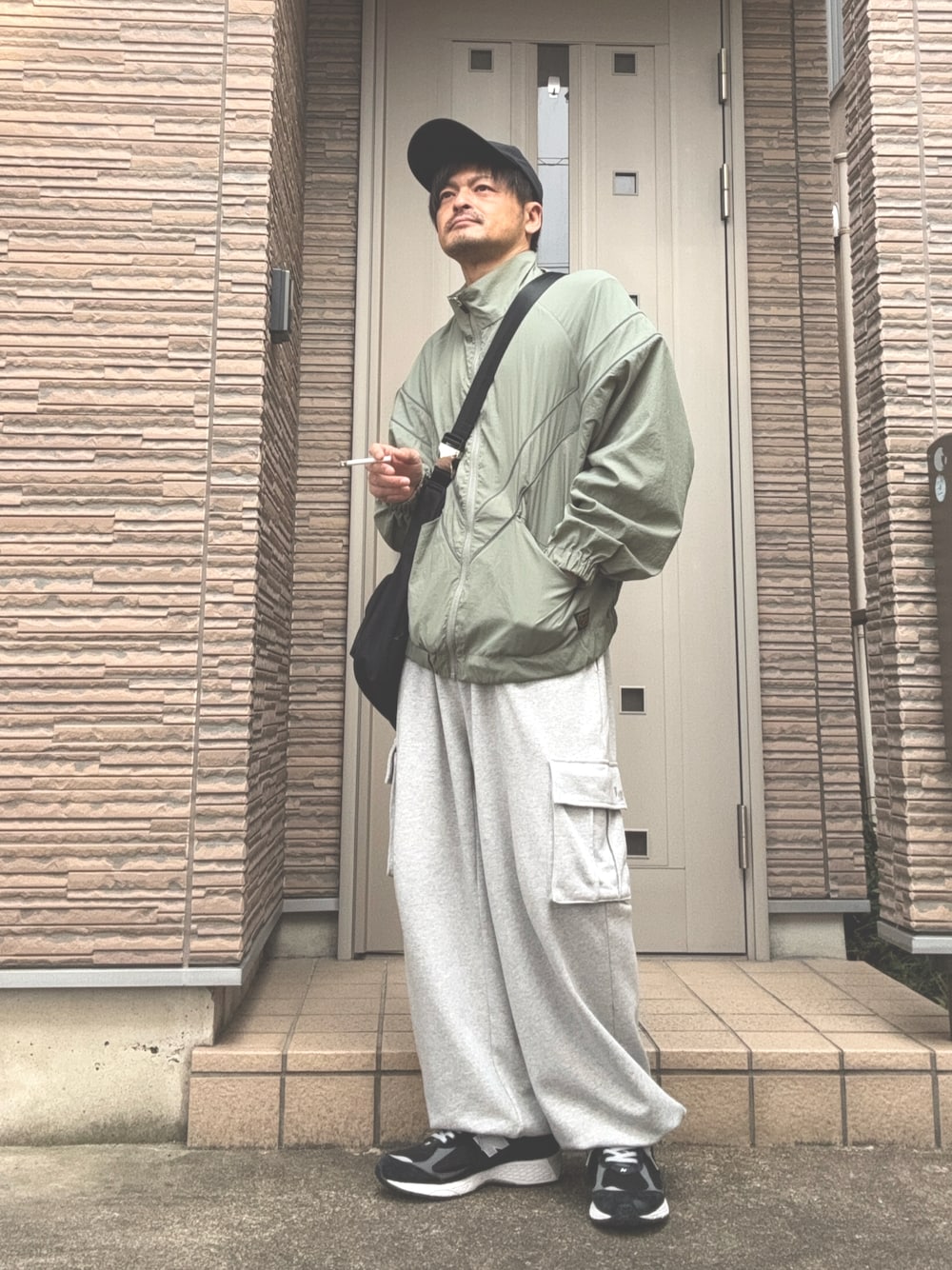 「春コーデ、カジュアル、スウェット、カーゴパンツ、スニーカー、ニューバランス、New Balance、キャップ、ショルダーバッグ、ナイロンジャケット、グリーン、大人カジュアル」｜「BAYFLOWのナイロントラックジャケット（ナイロンジャケット、グリーン系）」を使った、タルナンドさん（メンズ・165cm）の春コーディネートの1枚目の写真