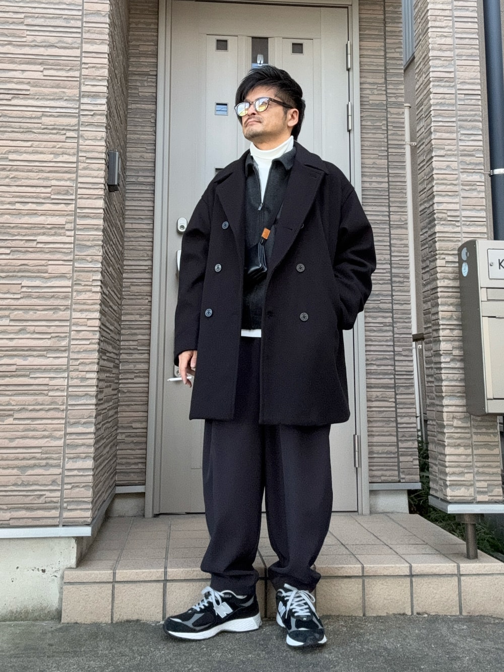「冬コーデ、きれいめカジュアル、コート、ピーコート、スニーカー、ニューバランス、New Balance、サングラス、タートルネック、レイヤードスタイル、大人コーデ」｜「NEW BALANCEの【New Balance / ニューバランス】M2002RX D（スニーカー、ブラック系）」を使った、タルナンドさん（メンズ・165cm）の冬コーディネートの1枚目の写真