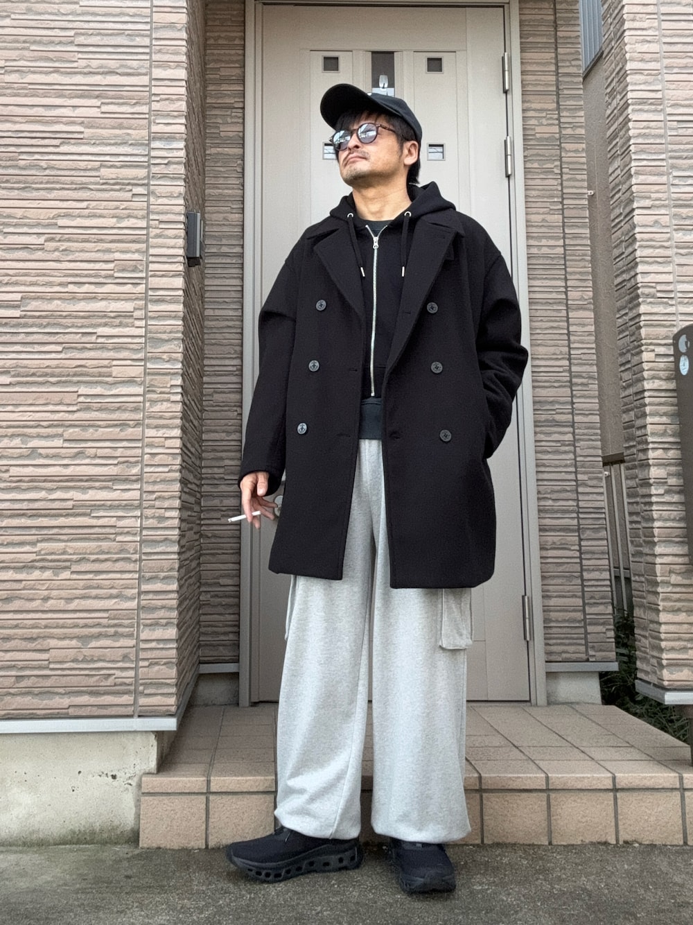 「冬コーデ、きれいめカジュアル、ピーコート、コート、キャップ、サングラス、スウェット、レイヤードスタイル、スニーカー、On、ショート丈、パーカー」｜「PBLIMのPAGEBOYLIM/スウェットカーゴパンツ（スウェットパンツ、グレー系）」を使った、タルナンドさん（メンズ・165cm）の冬コーディネートの1枚目の写真