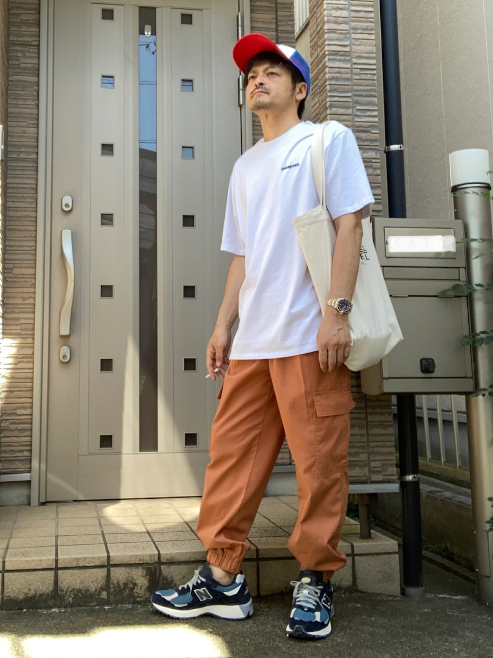 「夏コーデ、きれいめカジュアル、キャップ、GU、カーゴパンツ、オレンジ、スニーカー、New Balance、patagonia、ニューバランス」｜「GUのアイテム（カーゴパンツ、オレンジ系）」を使った、タルナンドさん（メンズ・165cm）の夏コーディネートの1枚目の写真