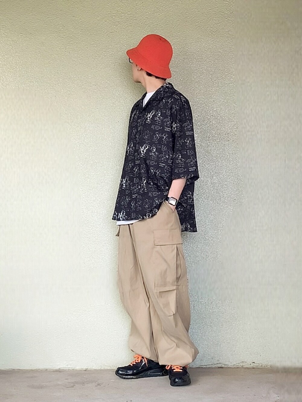 ブラック系のスニーカー、ブラック系のシャツ/ブラウス、オレンジ系のハットを着用したメンズの春コーディネートの1枚目の写真