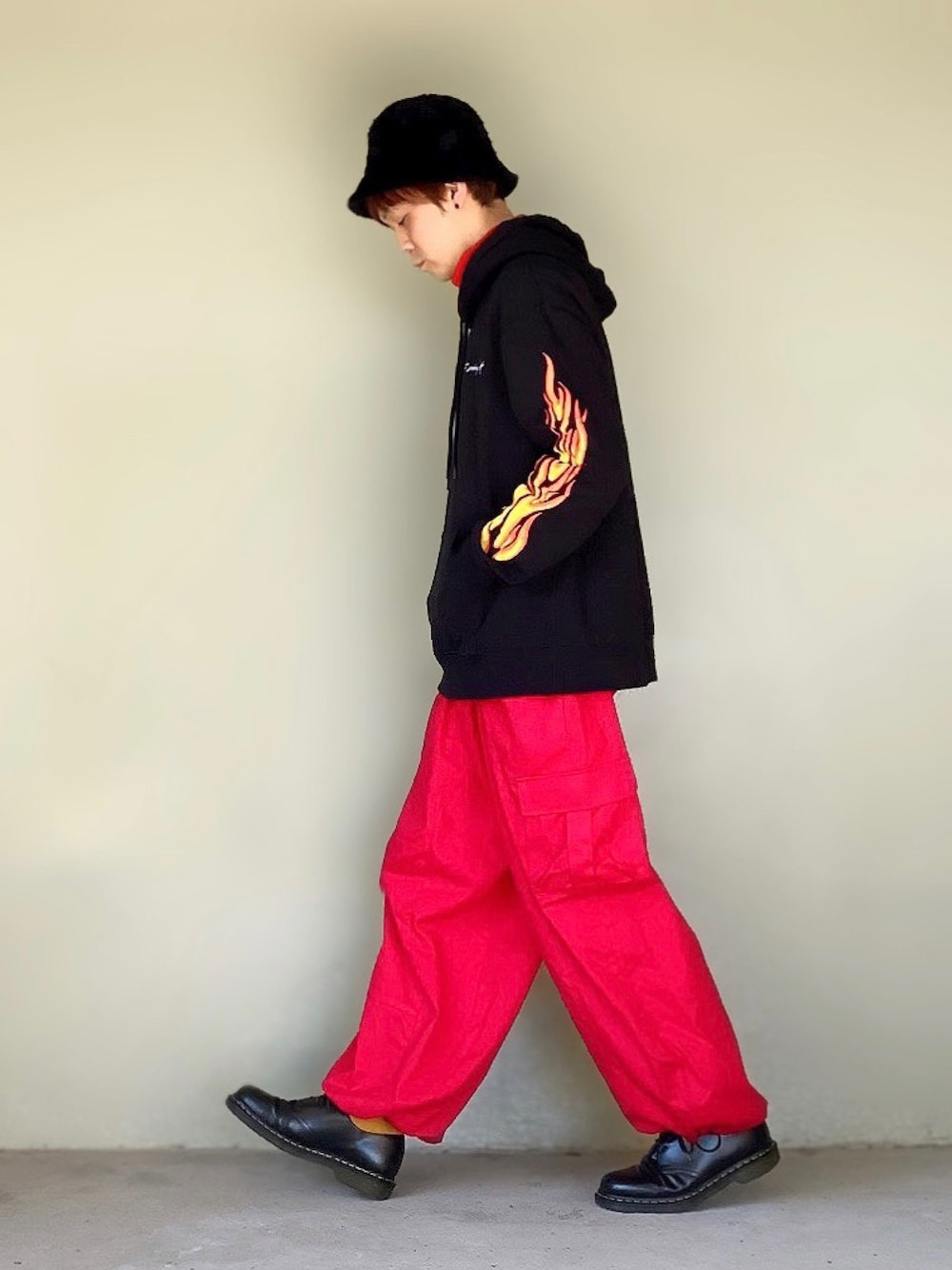 「カラーパンツ、パーカー、Dr.Martens、赤、レイヤードスタイル、タートルネック、カーゴパンツ、革靴、バケットハット、ファー帽子、カラーソックス、ゆるコーデ、ファイヤーパターン、袖プリント、STOP 誹謗中傷」｜「UNIQLOのタートルネックT（長袖）（Tシャツ/カットソー、オレンジ系）」を使った、サマルさん（メンズ・175cm）の秋コーディネートの1枚目の写真