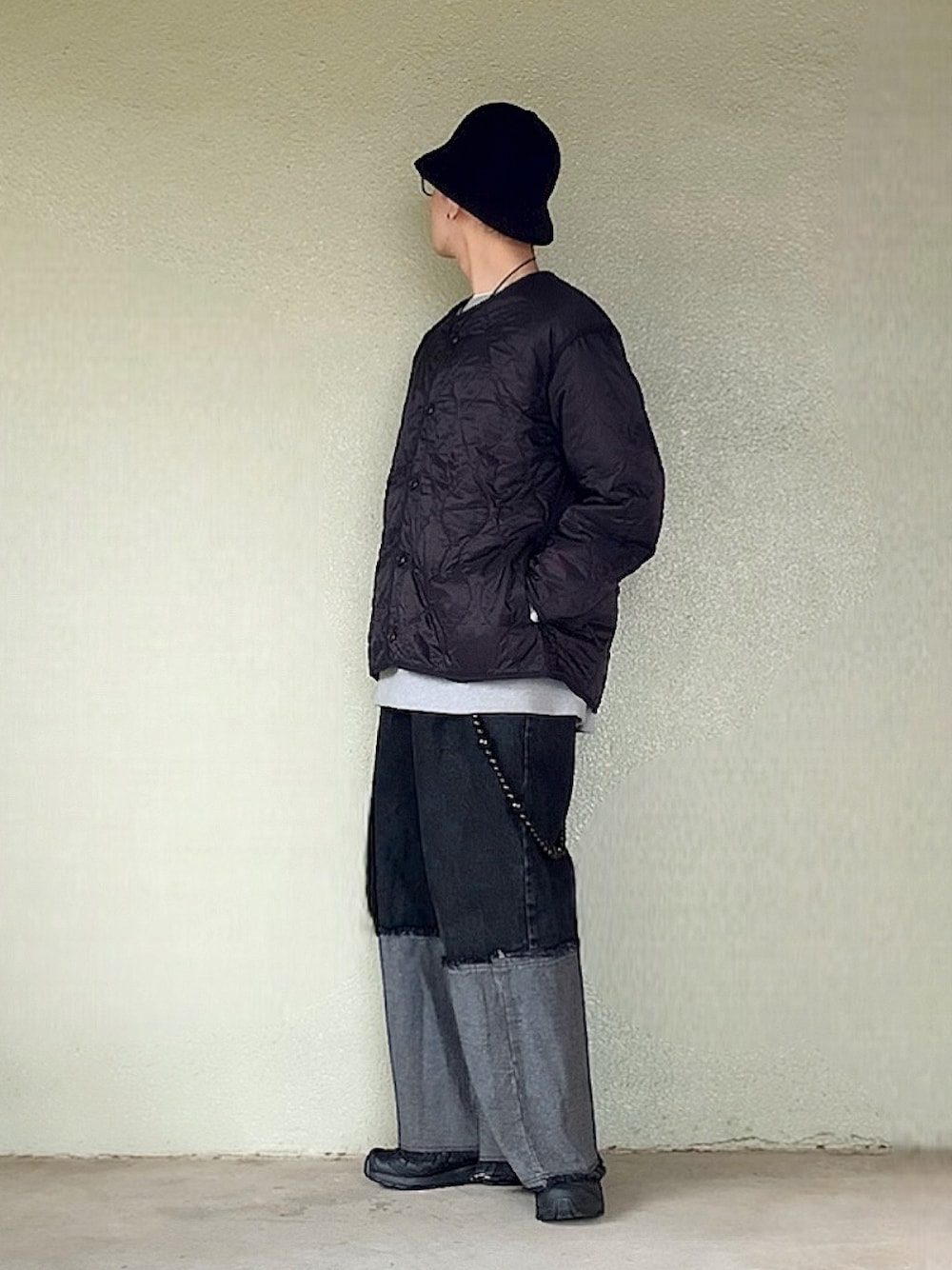 ブラック系のデニムパンツ、ブラック系のスニーカー、ブラック系のハットを着用したメンズの春コーディネートの1枚目の写真