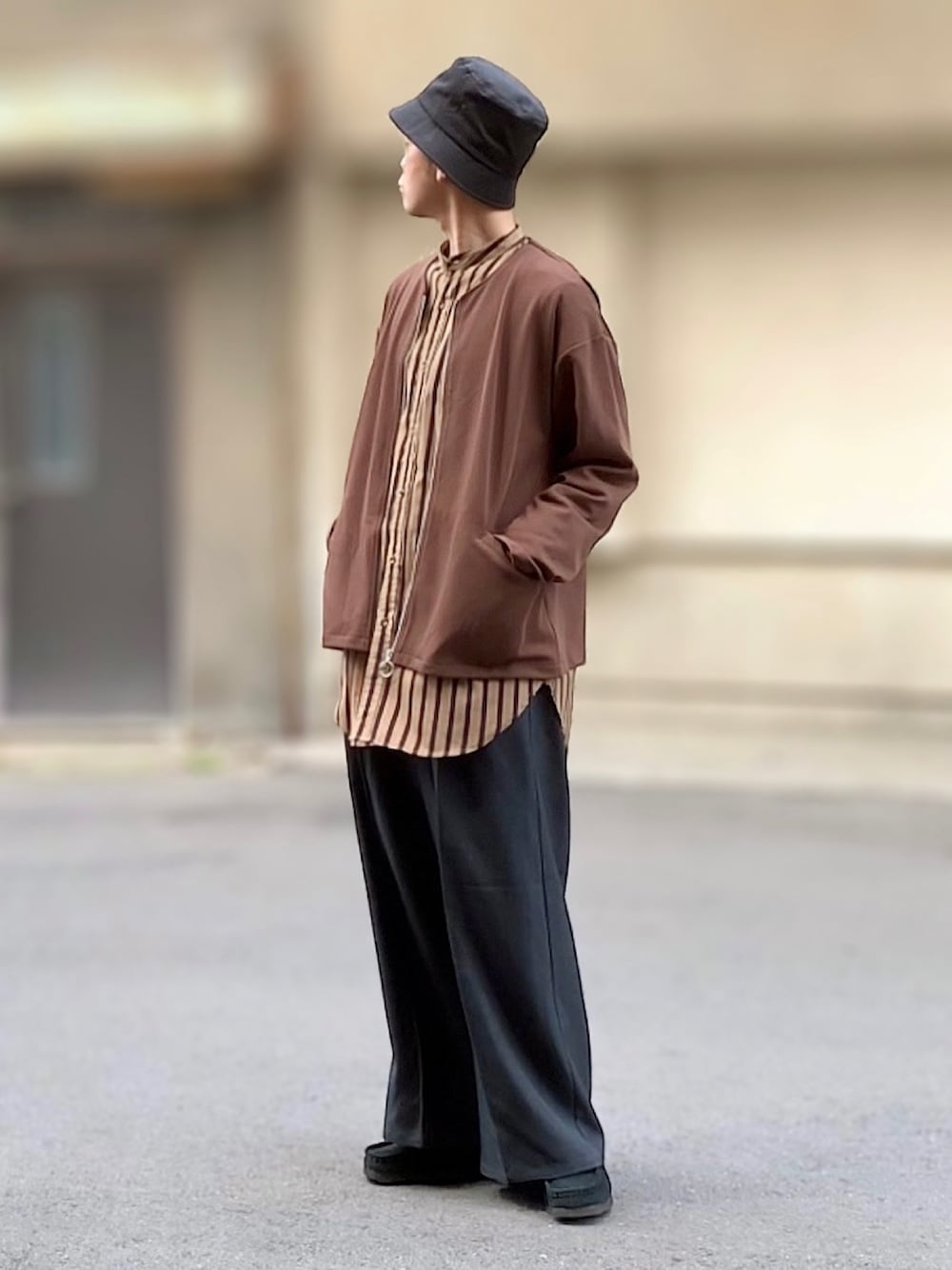 ブラック系のブーツ、ブラック系のスラックス、ベージュ系のシャツ/ブラウスを着用したメンズの春コーディネートの1枚目の写真