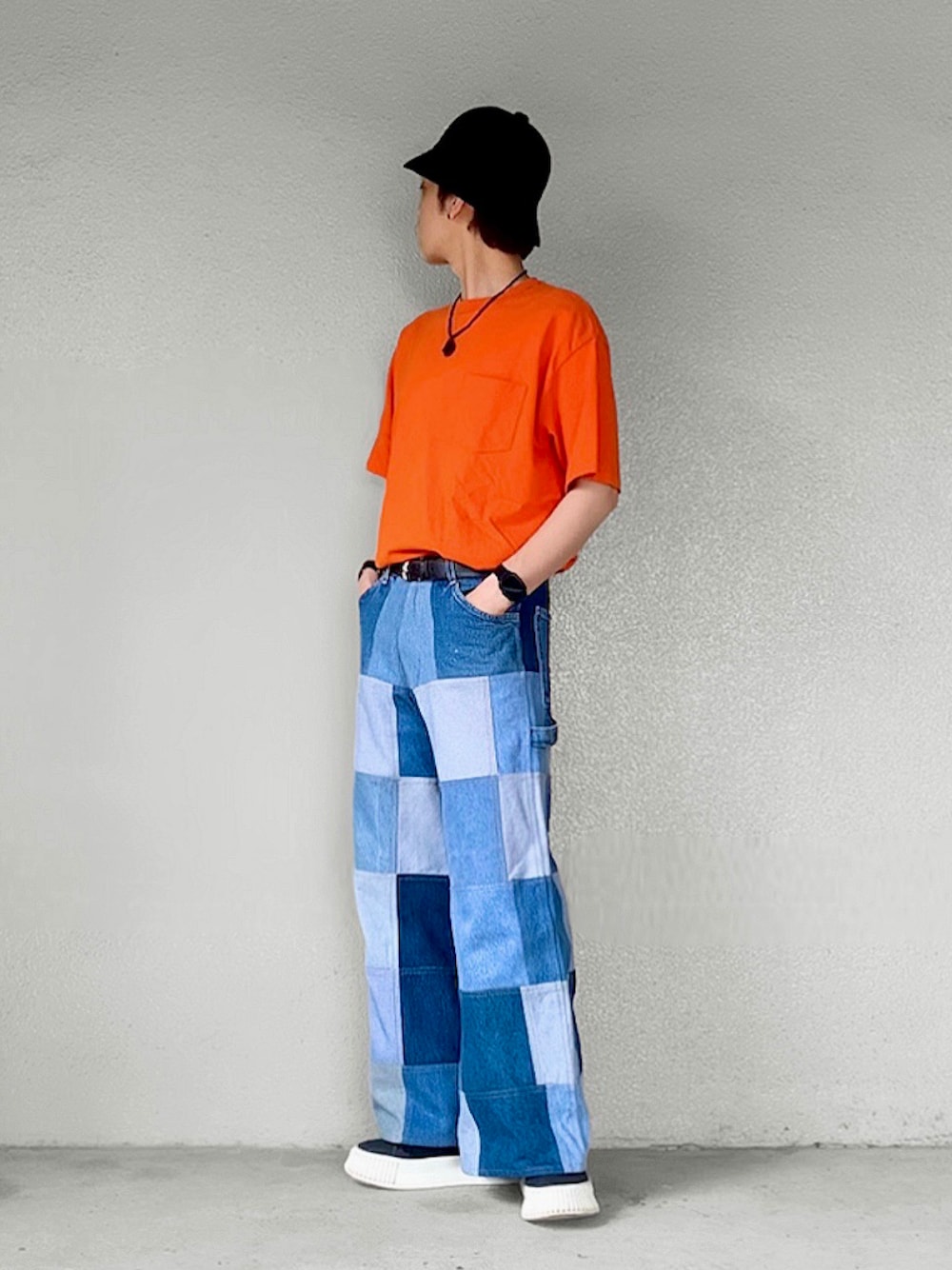 オレンジ系のTシャツ/カットソー、ブルー系のデニムパンツ、ブラック系のスニーカーを着用したメンズの夏コーディネートの1枚目の写真