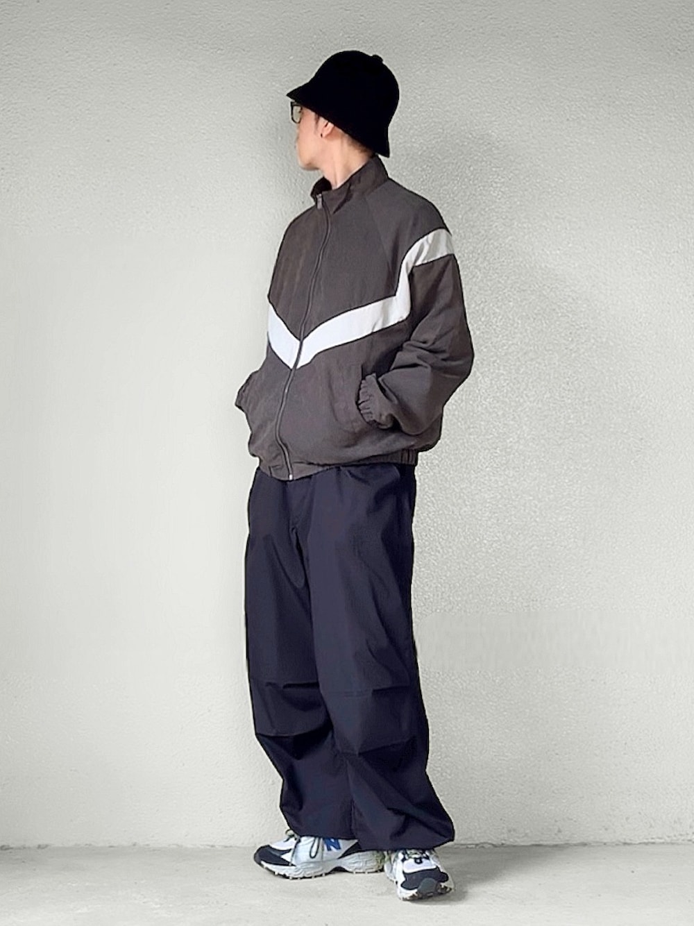 グレー系のジャージ、ブラック系のカーゴパンツ、グレー系のスニーカーを着用したメンズの秋コーディネートの1枚目の写真