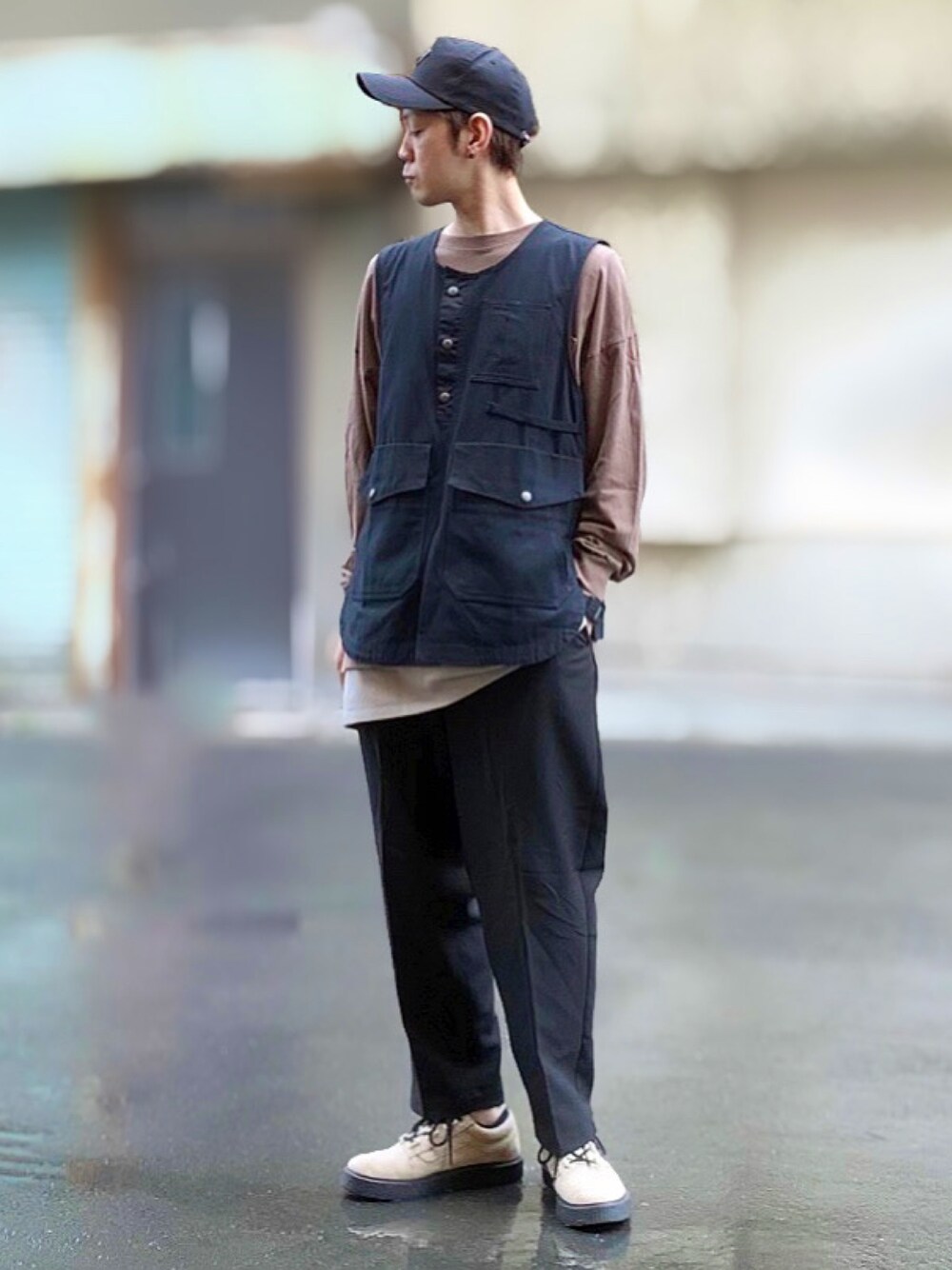 ブラック系のベスト、ブラウン系のTシャツ/カットソー、ベージュ系のタンクトップを着用したメンズの秋コーディネートの1枚目の写真