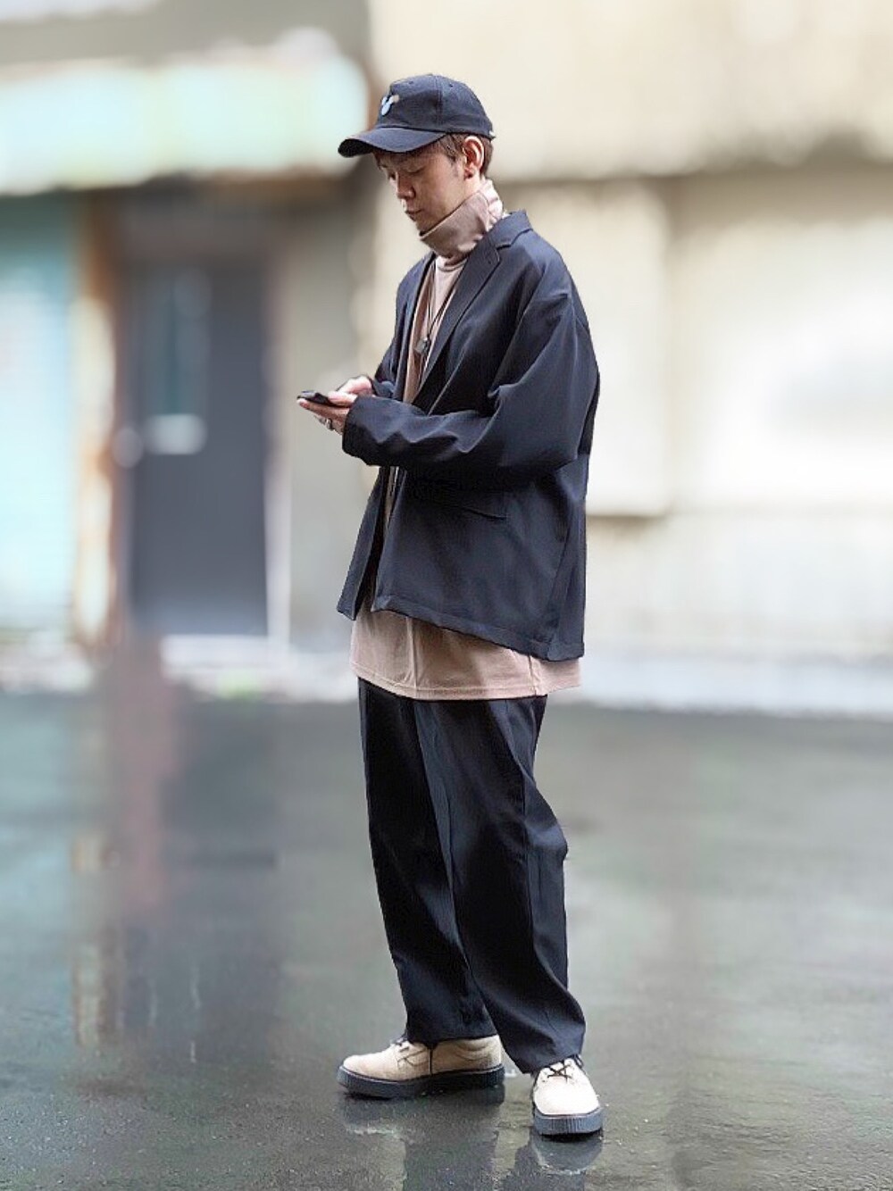 ブラック系のテーラードジャケット、ベージュ系のTシャツ/カットソー、ベージュ系のスニーカーを着用したメンズの秋コーディネートの1枚目の写真